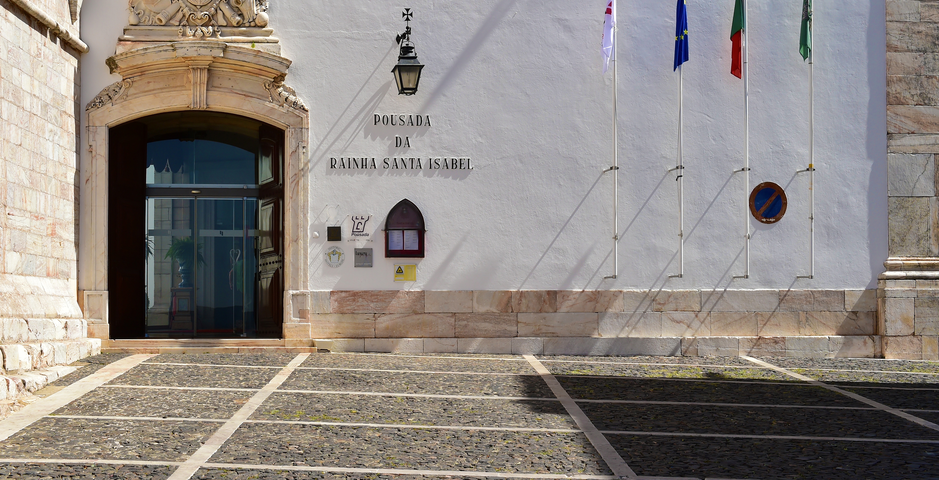 Eingang des Hotels im historischen Zentrum von Estremoz mit kunstvollen Details und mehreren Fahnen