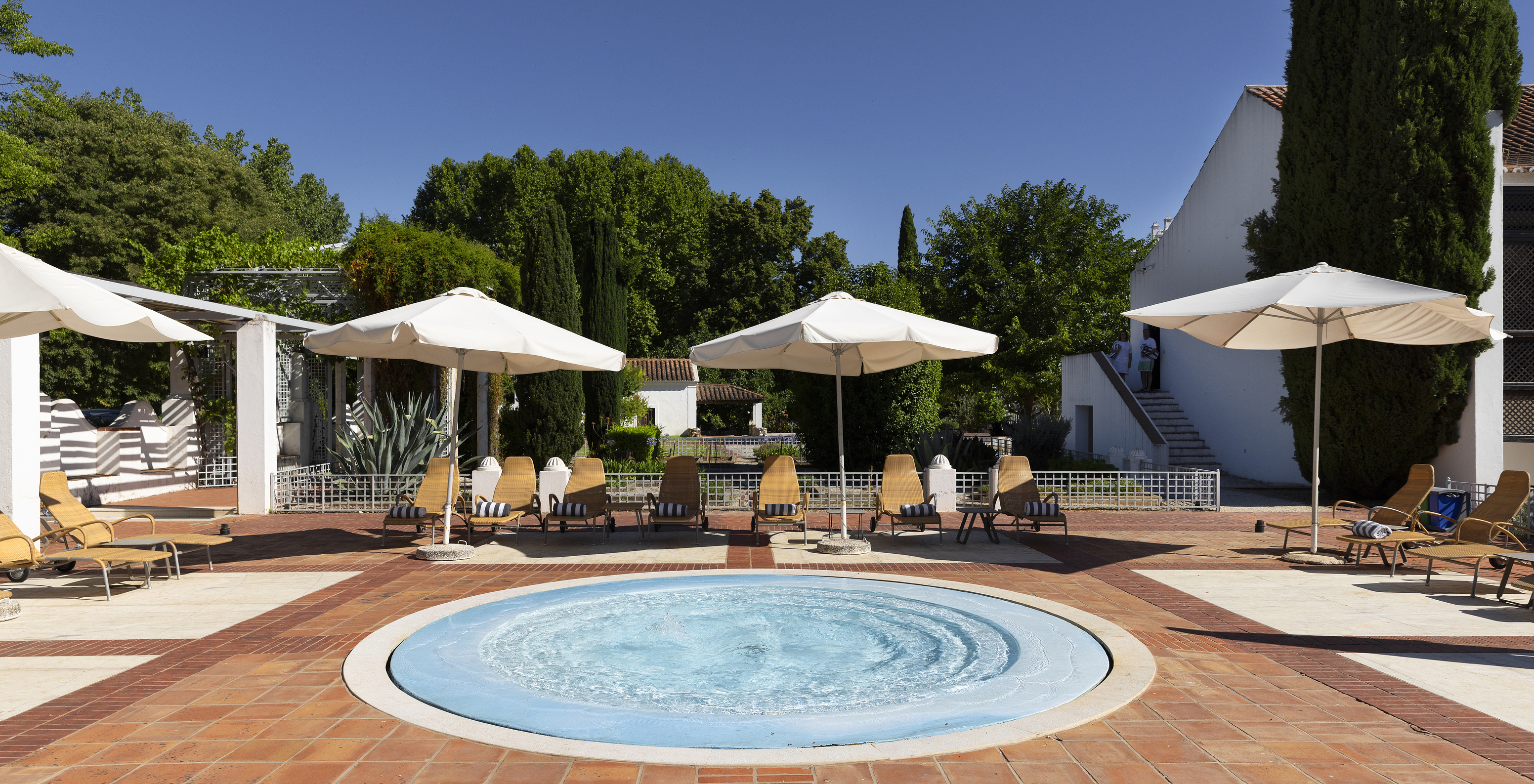 Kleiner runder Pool in der Pousada Convento Vila Viçosa mit Liegen und Sonnenschirmen