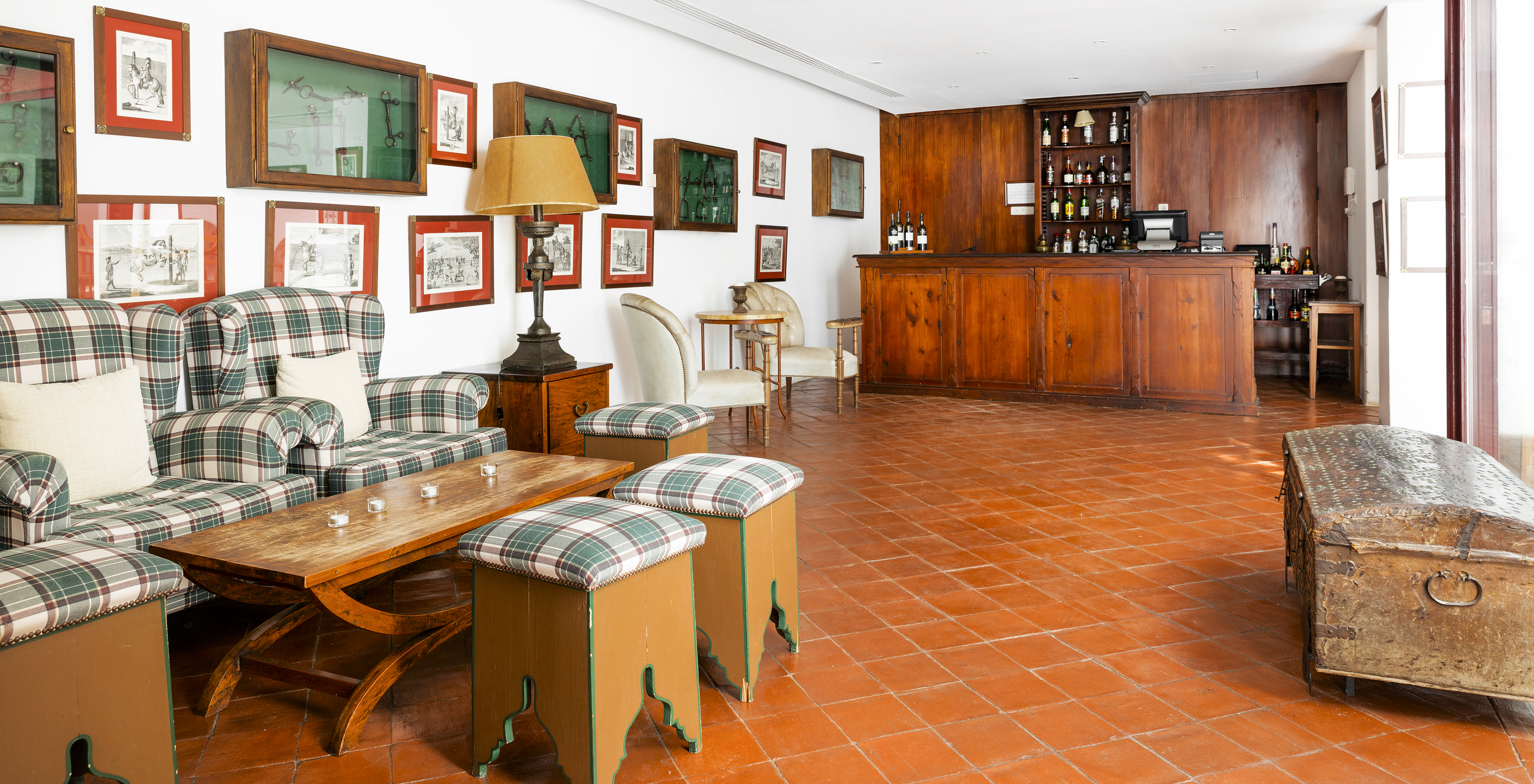 Die Bar im historischen Hotel in Vila Viçosa hat grüne Sessel mit Beistelltisch und Bilder an der Wand