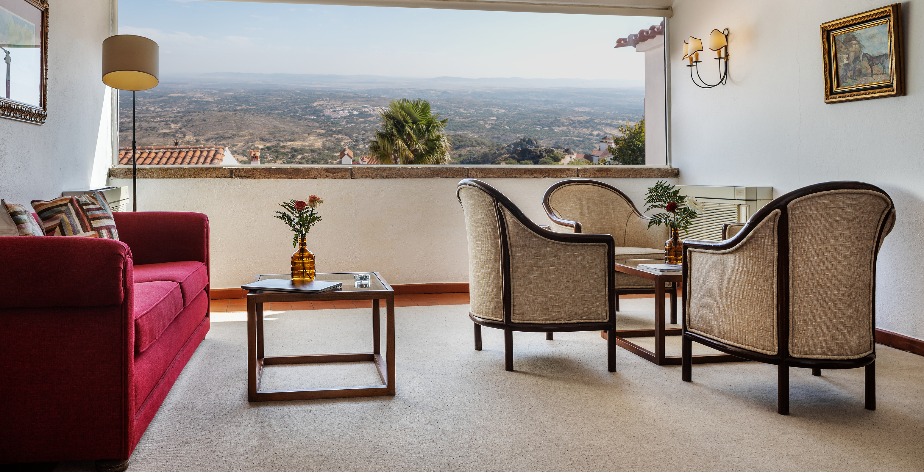 Pousada Marvão, ein Hotel im Zentrum von Marvão mit einem Sofa, einem Tisch mit Sesseln und einem großen Fenster