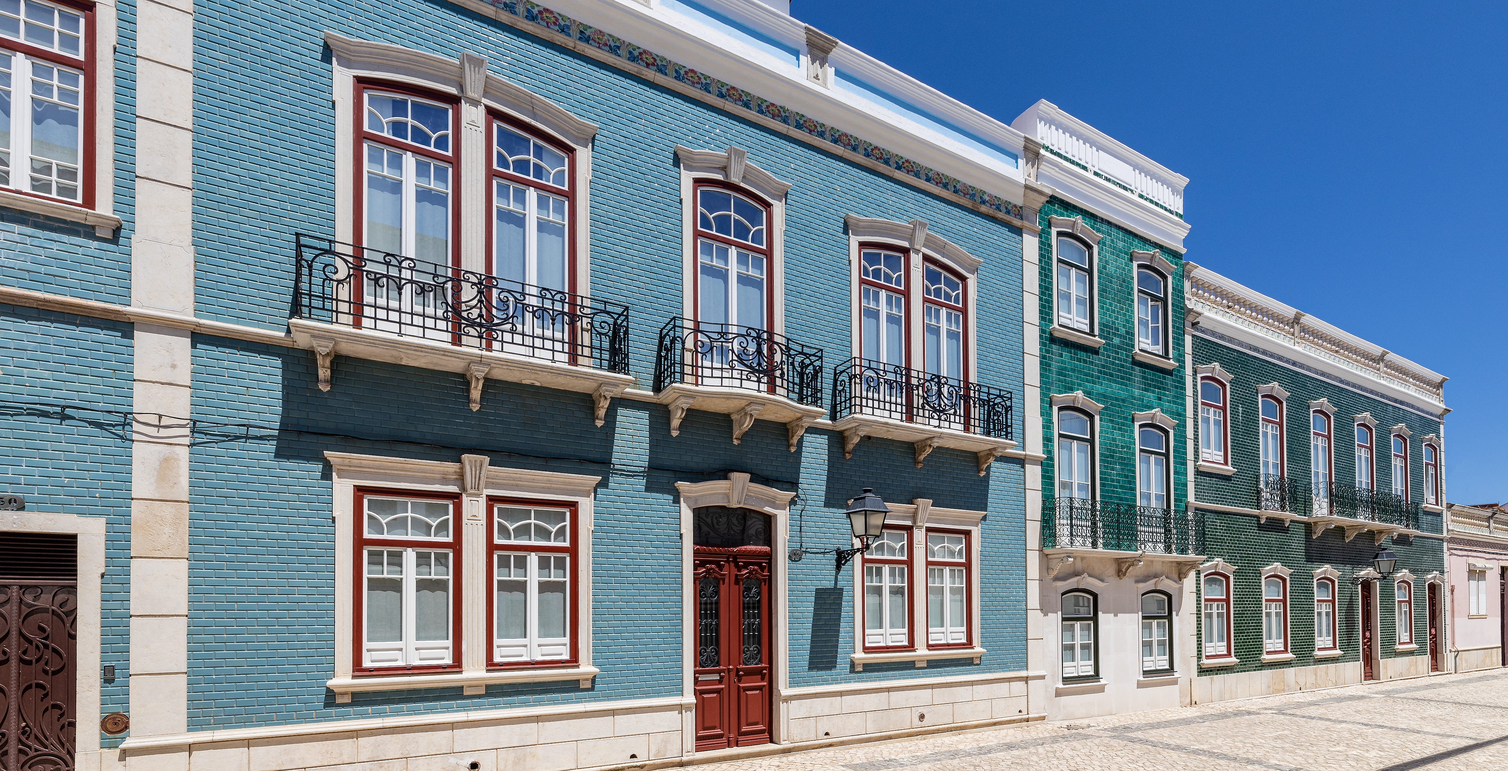 Gebäude der Pousada Vila Real de Santo António mit Eisenbalkonen und blauen sowie grünen Fliesen