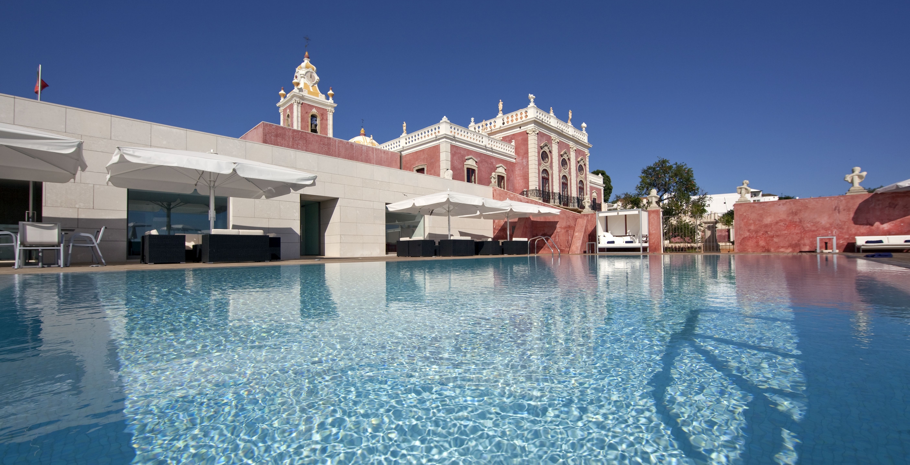 Außenpool der Pousada Palácio Estoi, historisches Hotel in der Algarve mit Pool, mit Sonnenschirmen, Liegen und Sofas