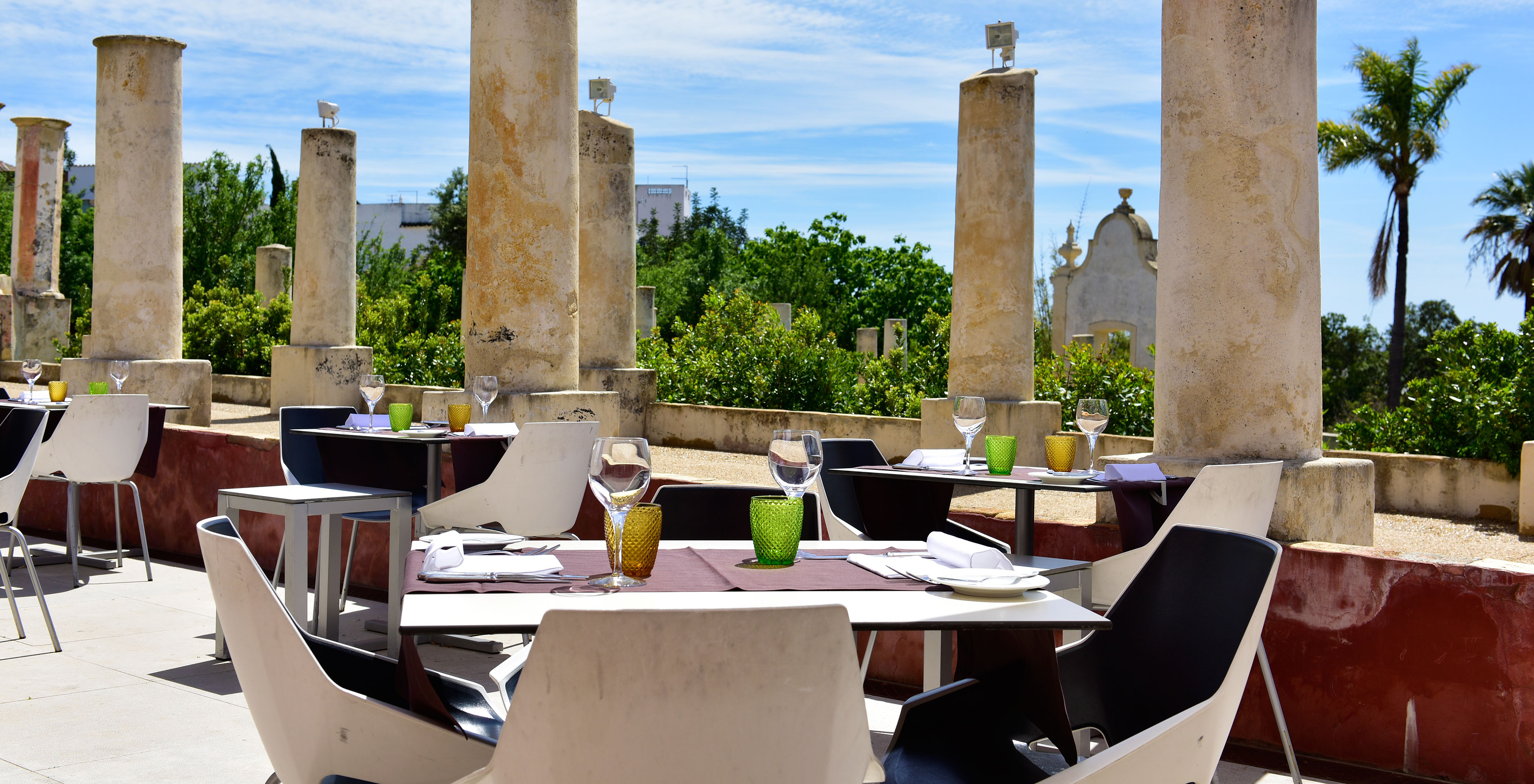 Das Restaurant Visconde, im historischen Hotel in Faro, hat Tische im Freien, mit Steinsäulen im Hintergrund