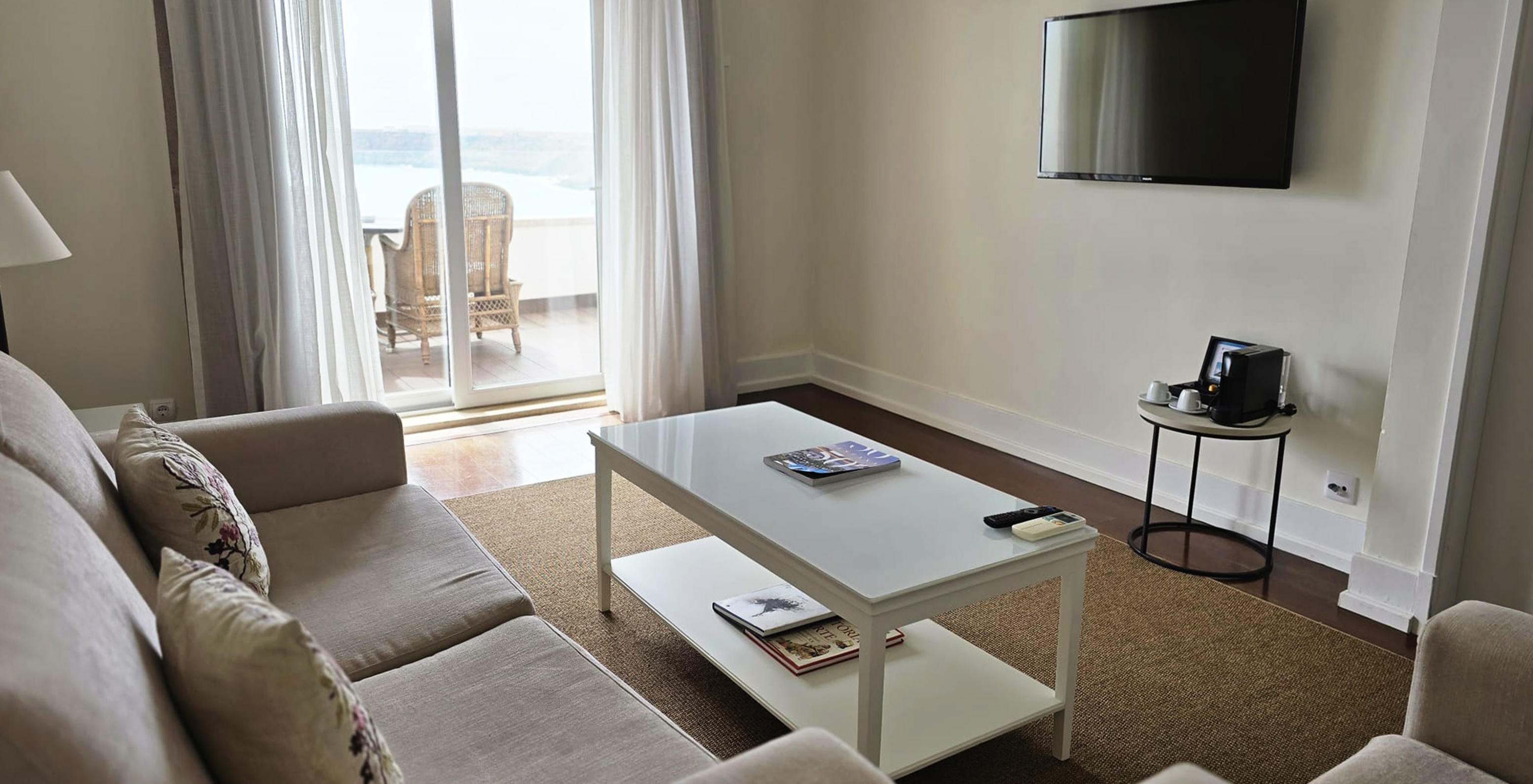 Die Special Suite der Pousada Sagres hat ein Wohnzimmer mit Sofa, Fernseher und Balkon