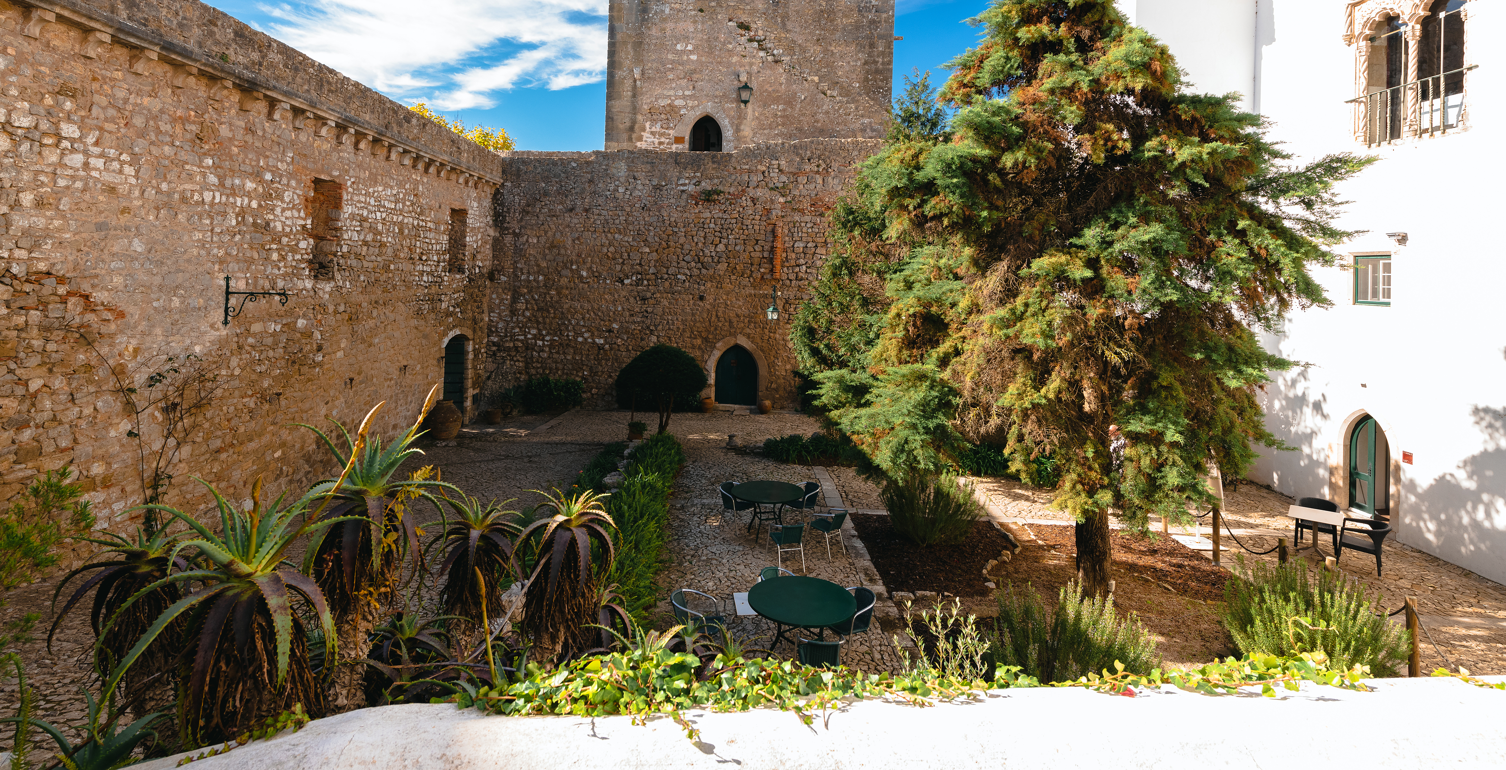 Blick auf den Außenhof der Pousada Castelo Óbidos mit Stühlen und Tischen für die Entspannung der Gäste