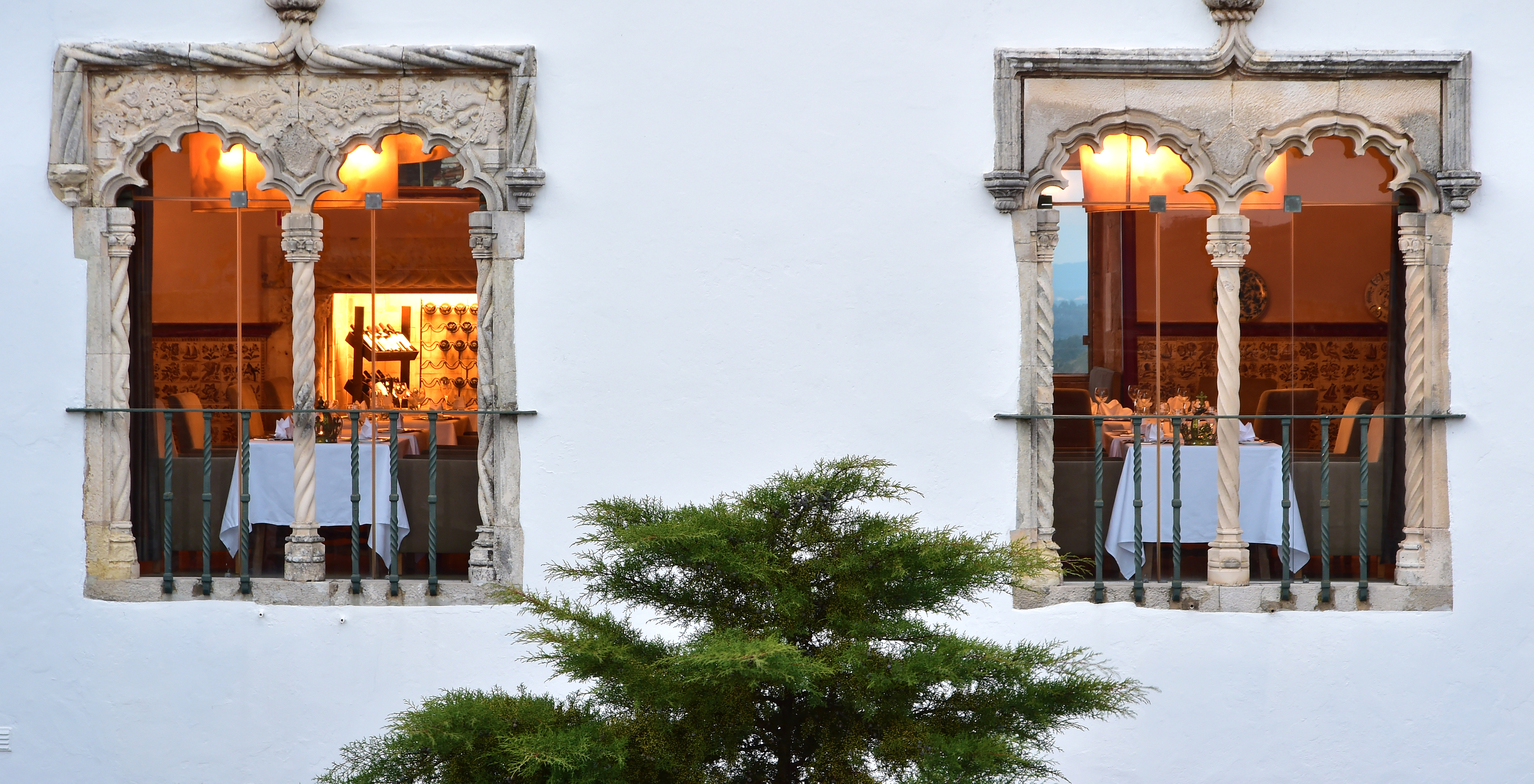 Das Restaurant Pousada Castelo Óbidos, im historischen Hotel, hat einen Raum mit Tischen und Stühlen mit Blick auf das Dorf