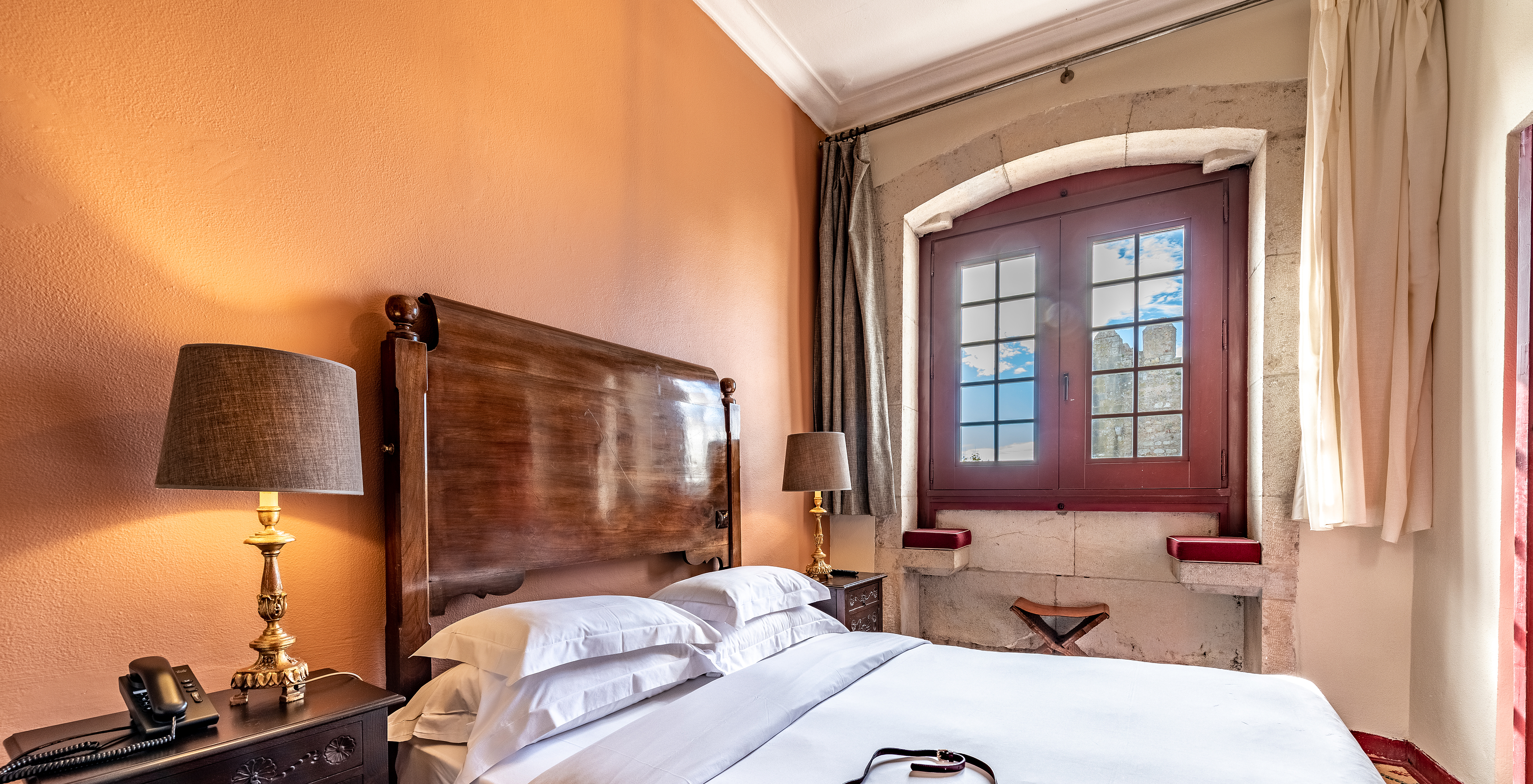 Das Klassische Zimmer Castelo der Pousada Castelo Óbidos hat ein Doppelbett und ein Fenster mit Blick auf das Schloss