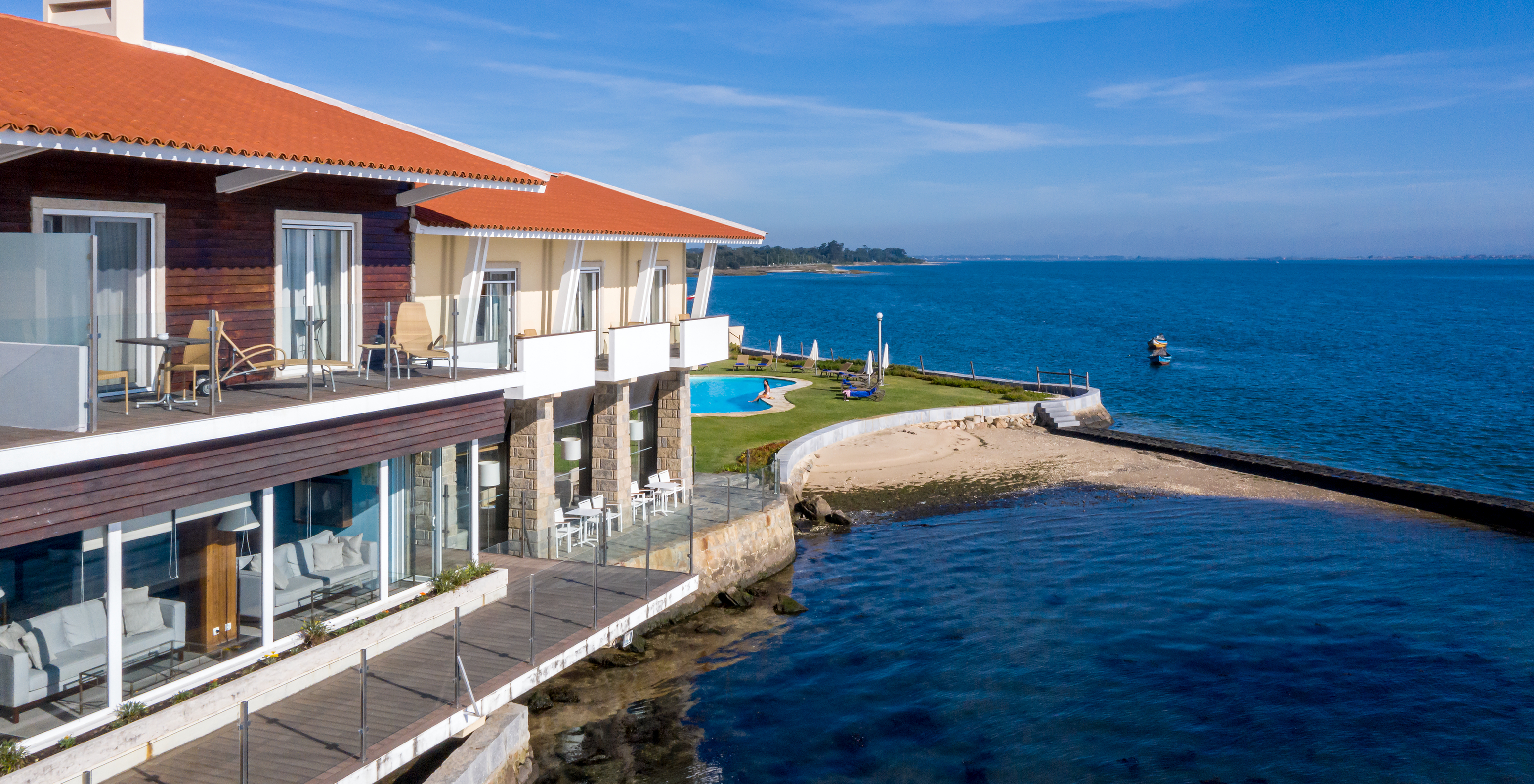 Fassade der Pousada Ria in Aveiro mit Pool, Freizeitbereich und direktem Zugang zum Strand vor einem ruhigen Meer