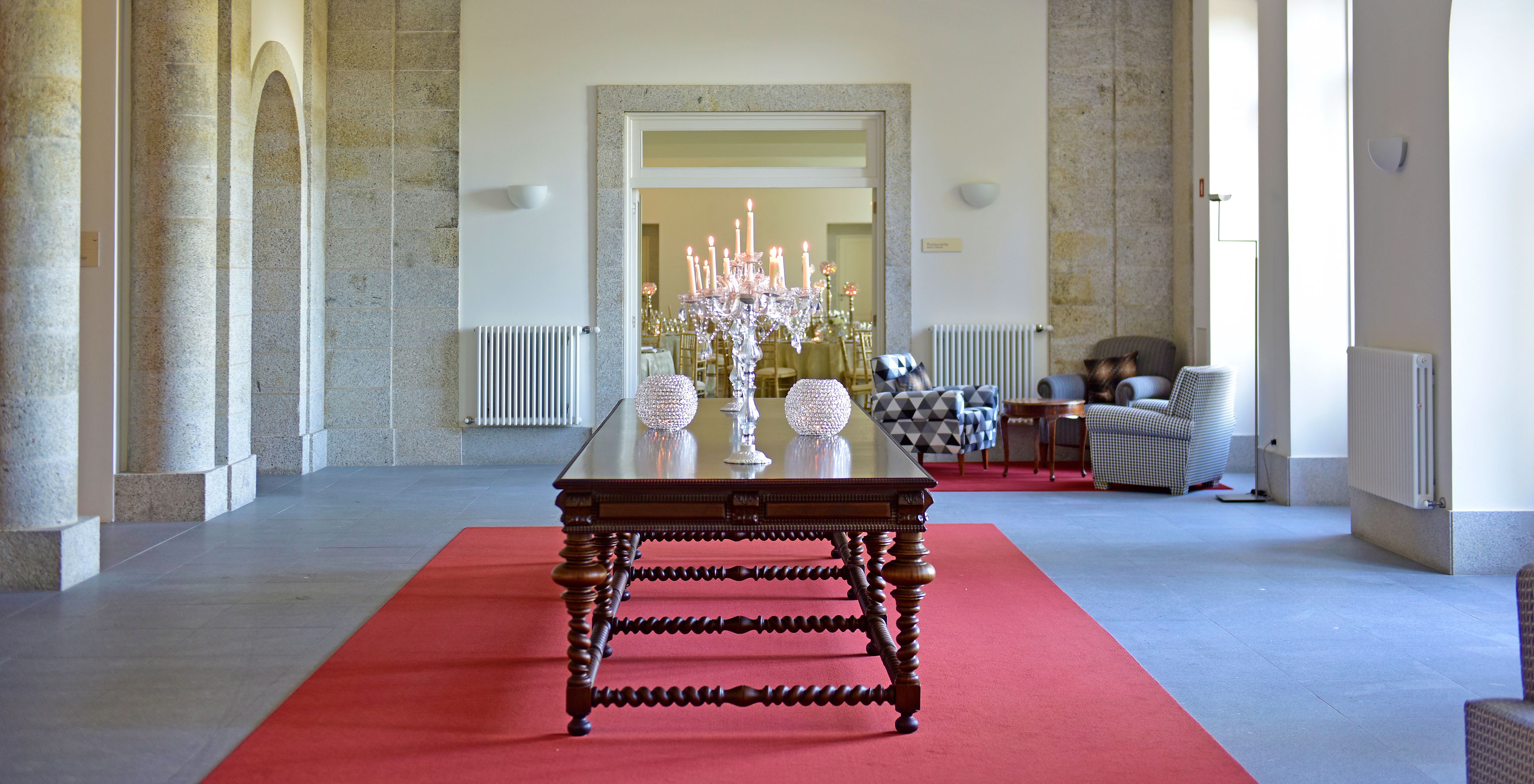 Lobby des Berg-Hotels im Zentrum Portugals, mit einem großen Holztisch und einem Kerzenhalter