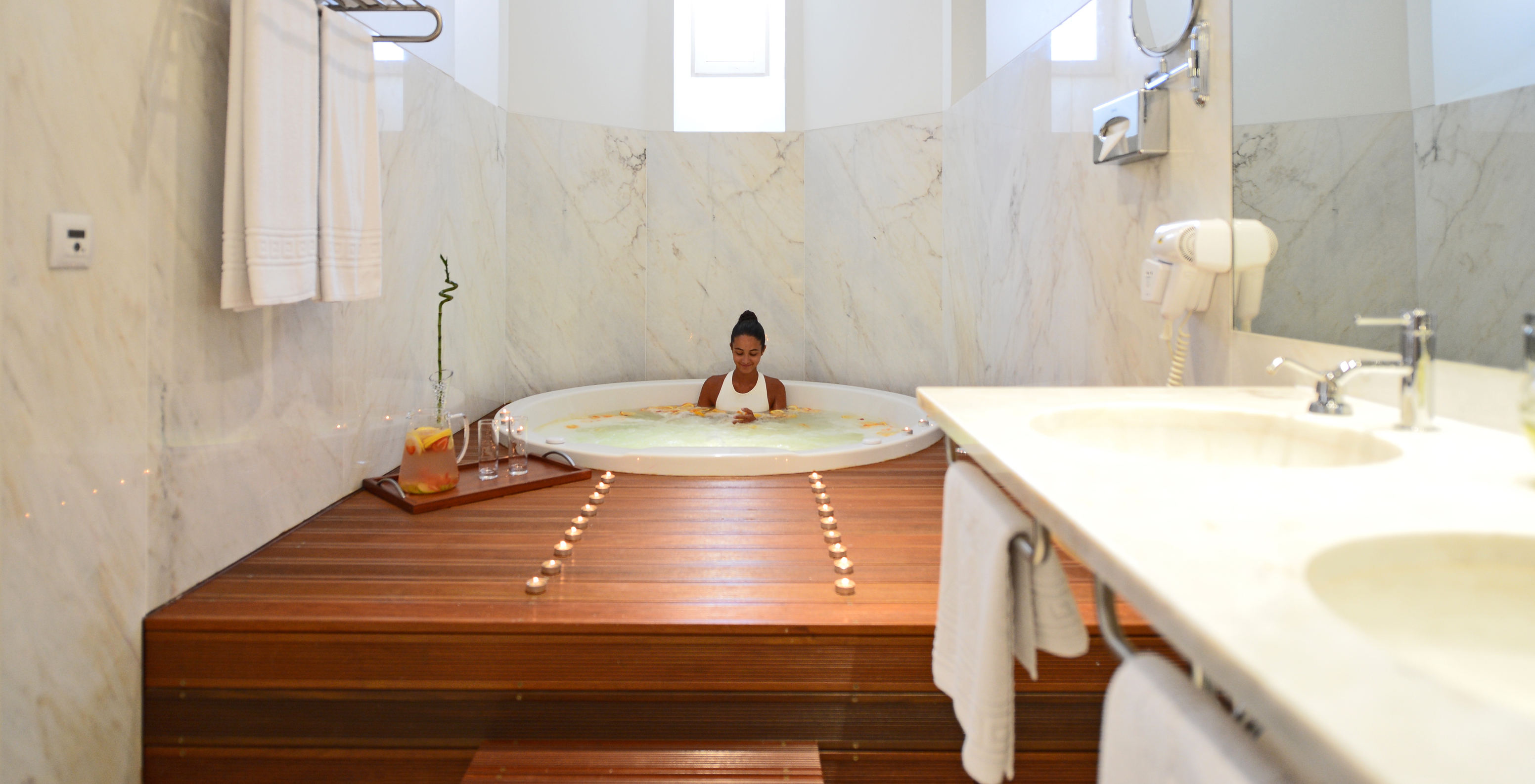 Das Spa Zimmer der Pousada Serra da Estrela hat ein Badezimmer mit Jacuzzi mit Holzdeck, Waschbecken und Spiegel