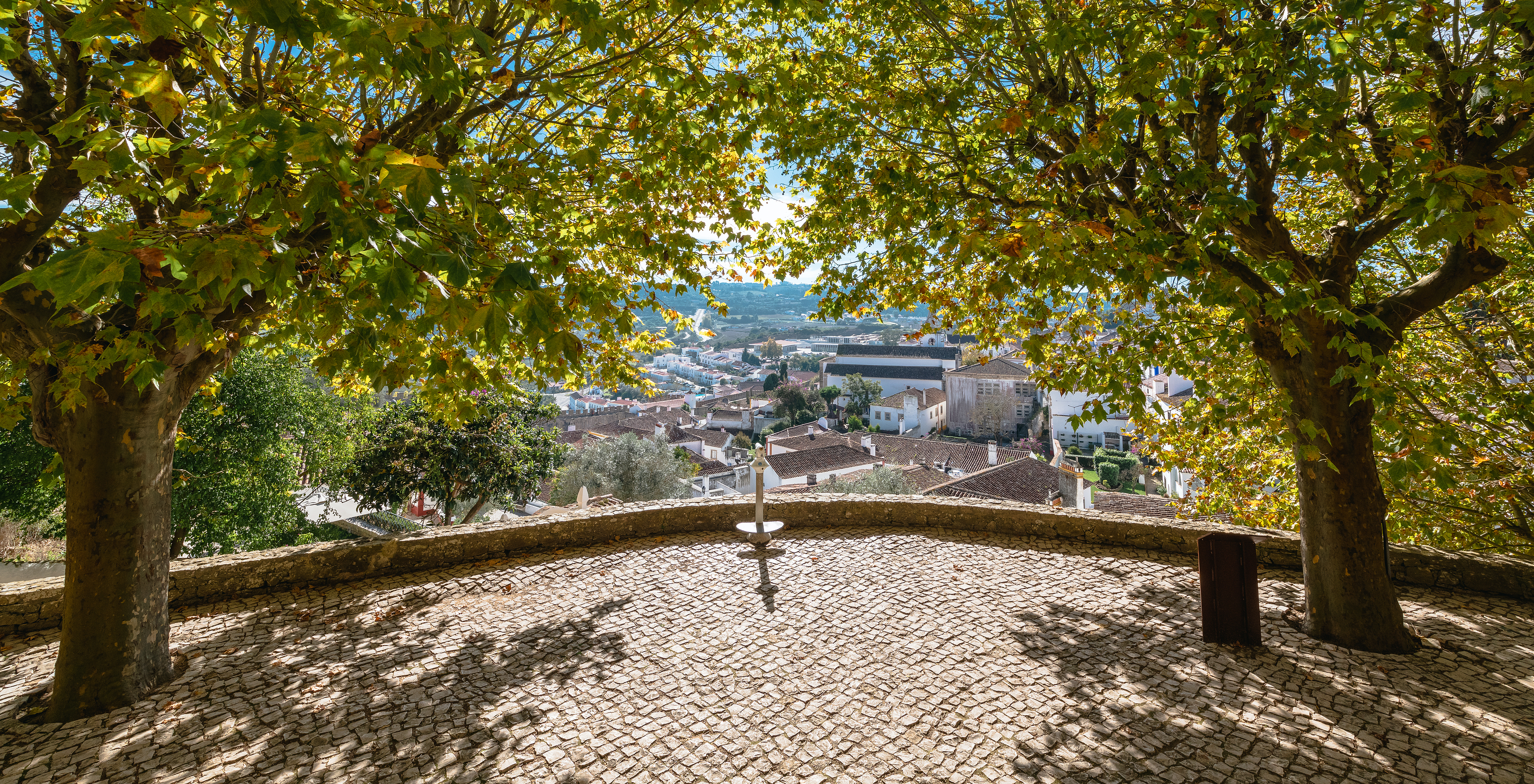 Blick auf die Pousada Vila Óbidos mit bunten Häusern und der Burg im Hintergrund