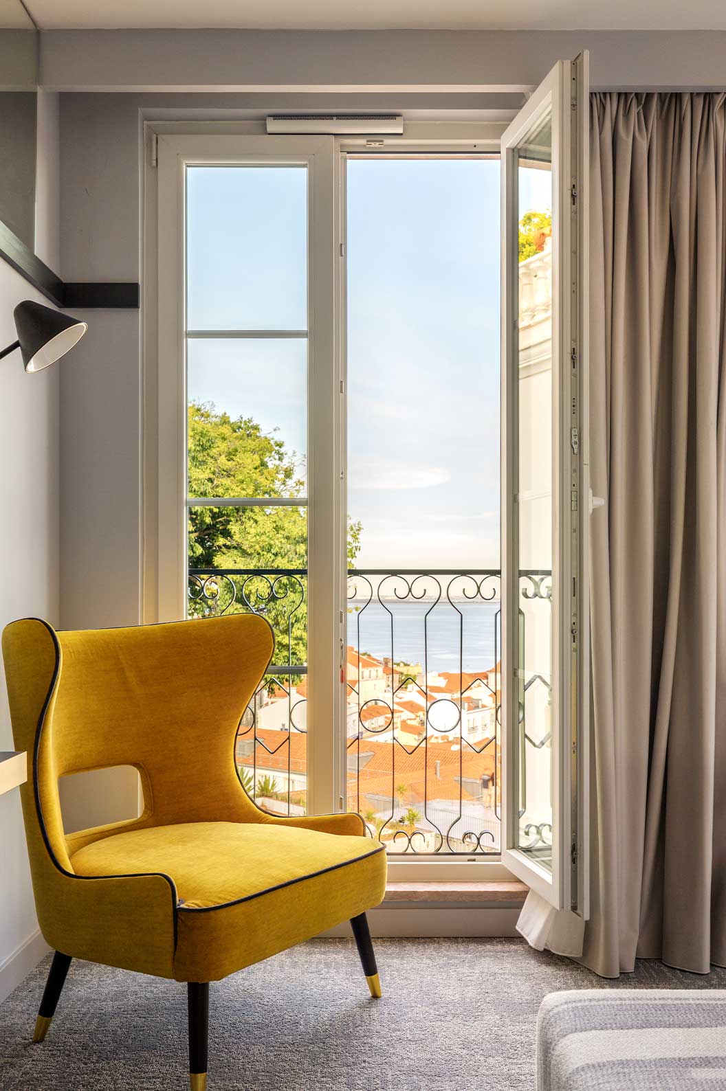 Das Superior River View Plus der Pousada Alfama hat ein Doppelbett mit zwei großen Fenstern mit Blick auf den Tejo