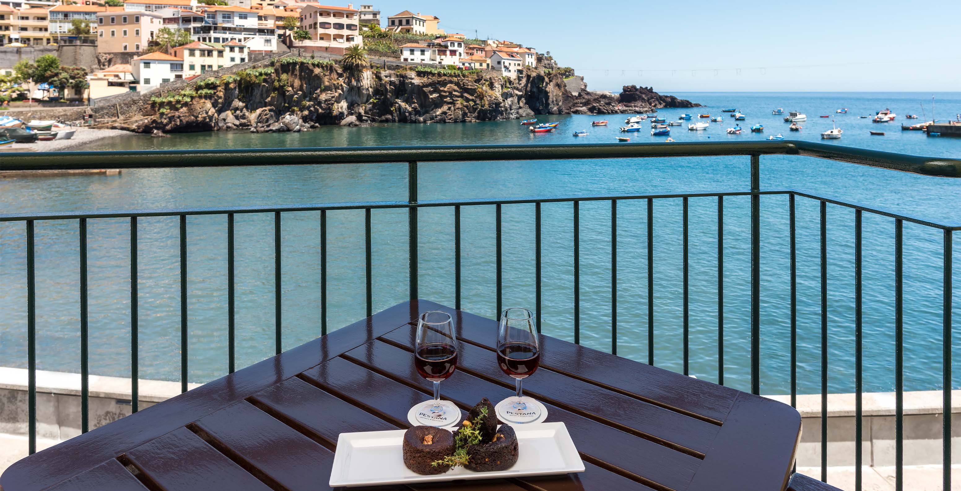 Das Deluxe Superior Bay View Zimmer im Pestana Churchill Bay hat einen Balkon mit Meerblick, wo man Wein trinken kann