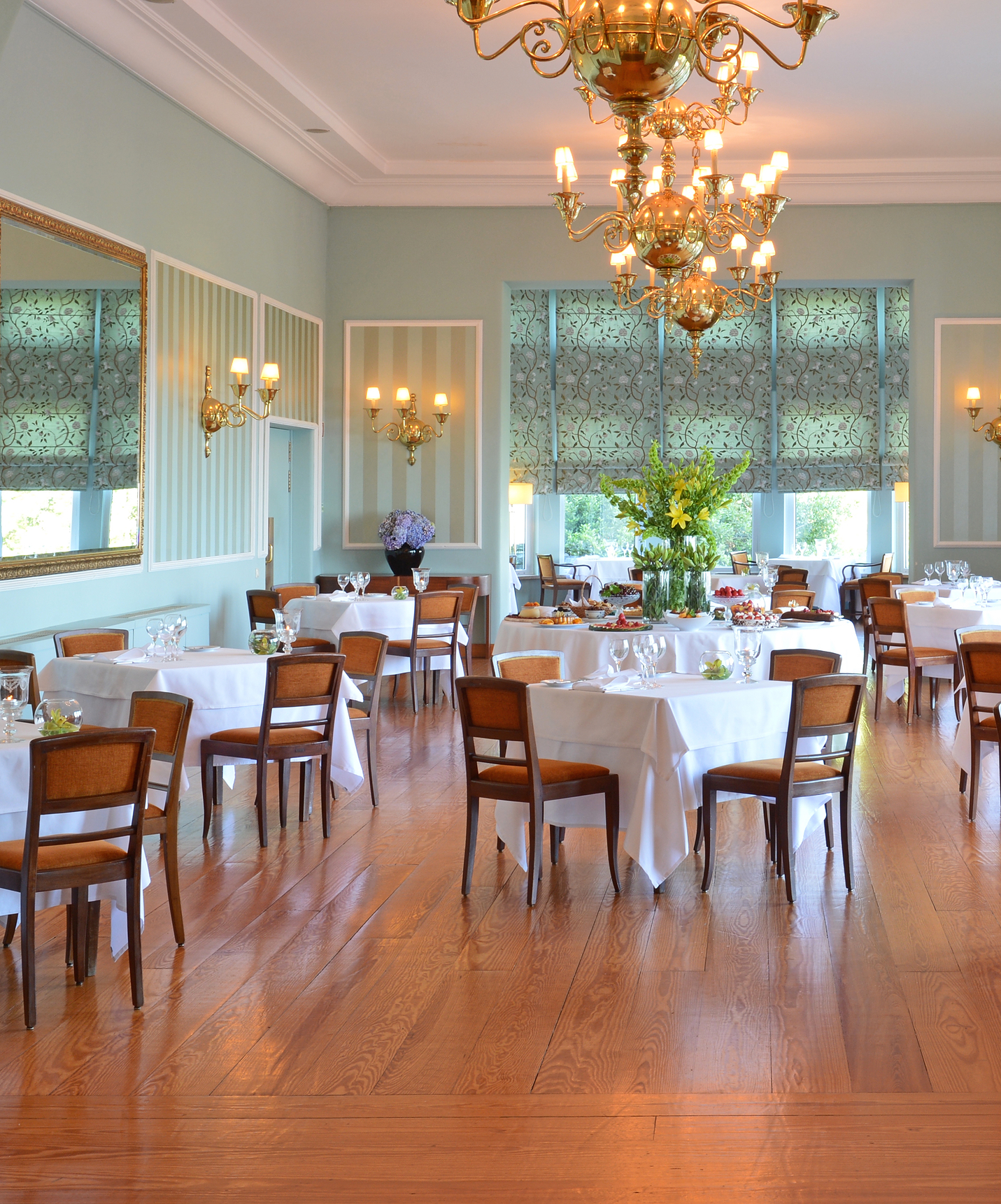 Speisesaal mit quadratischen Tischen und vier Stühlen, mit großen Lampen, wo man die lokale Gastronomie probieren kann