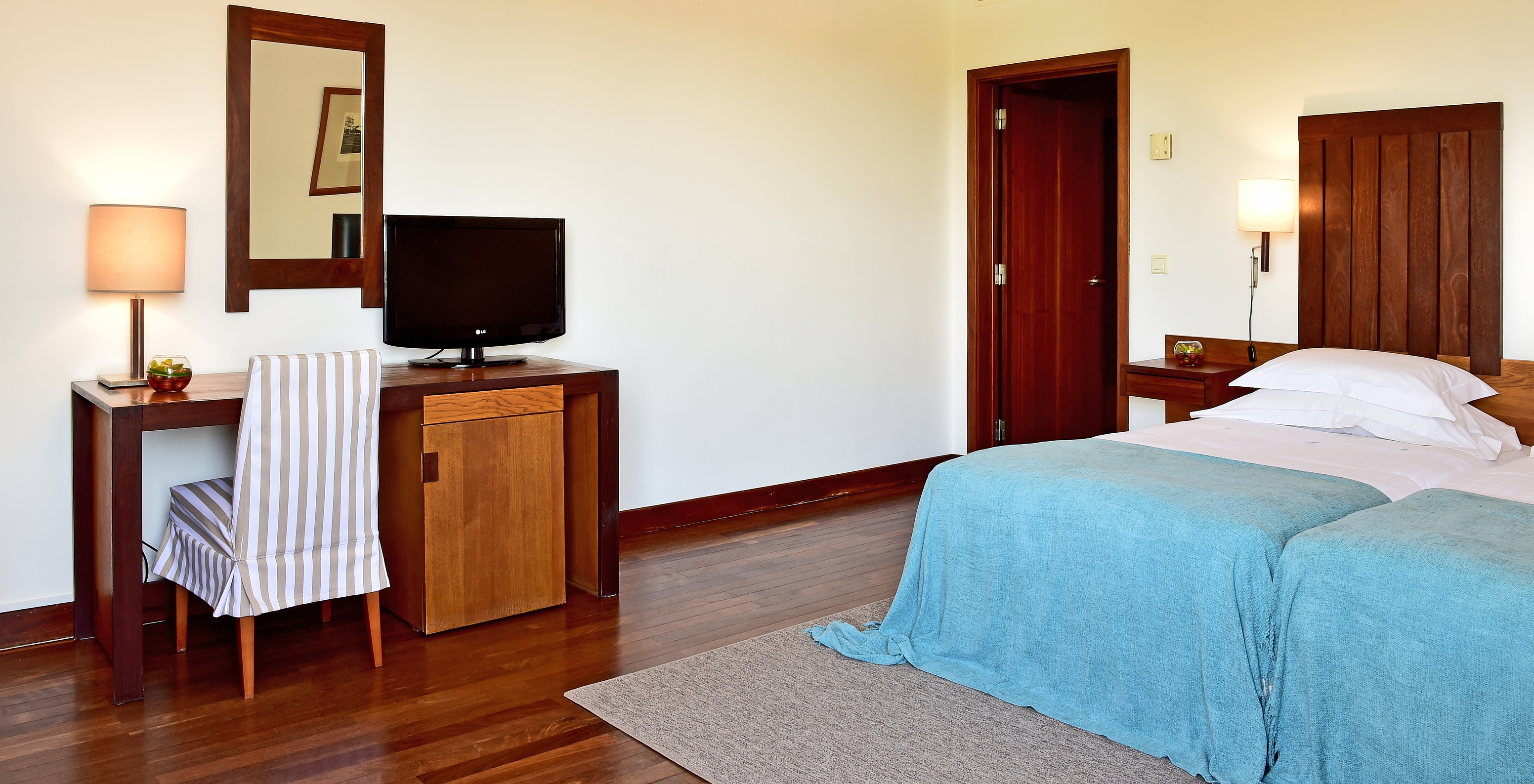 The Classic Room of the Pousada Castelo Alcácer do Sal has a desk with a television and two separate beds