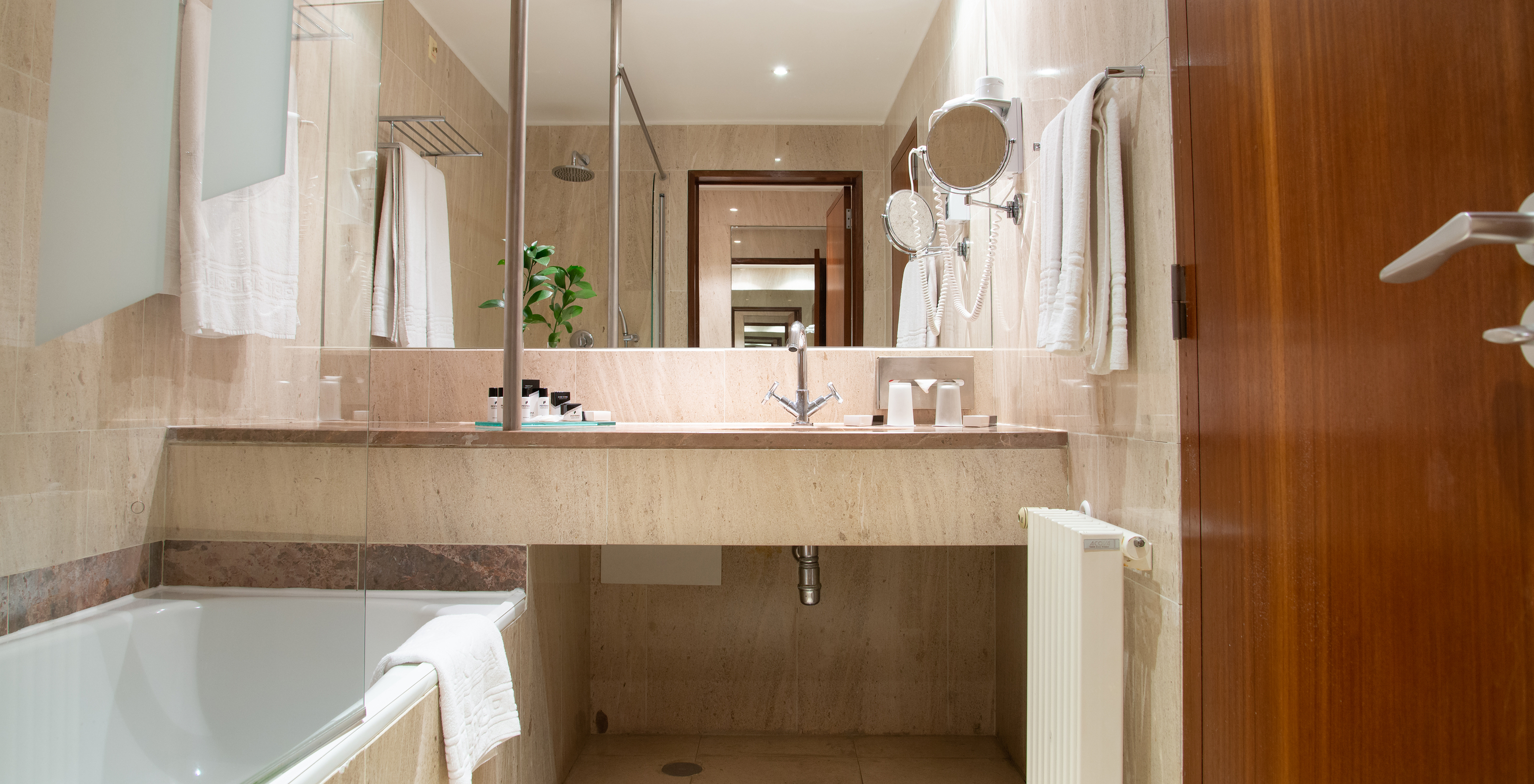 The Junior Suite of the Pousada Castelo Alcácer do Sal has a bathroom with a bathtub, sink, and mirror