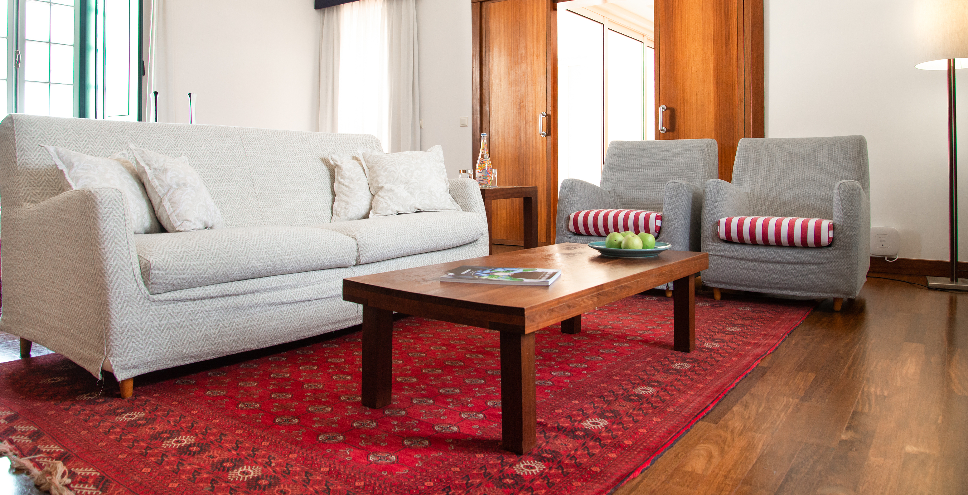 The Special Suite of the Pousada Castelo Alcácer do Sal has a sofa, two armchairs, a red rug, and a table