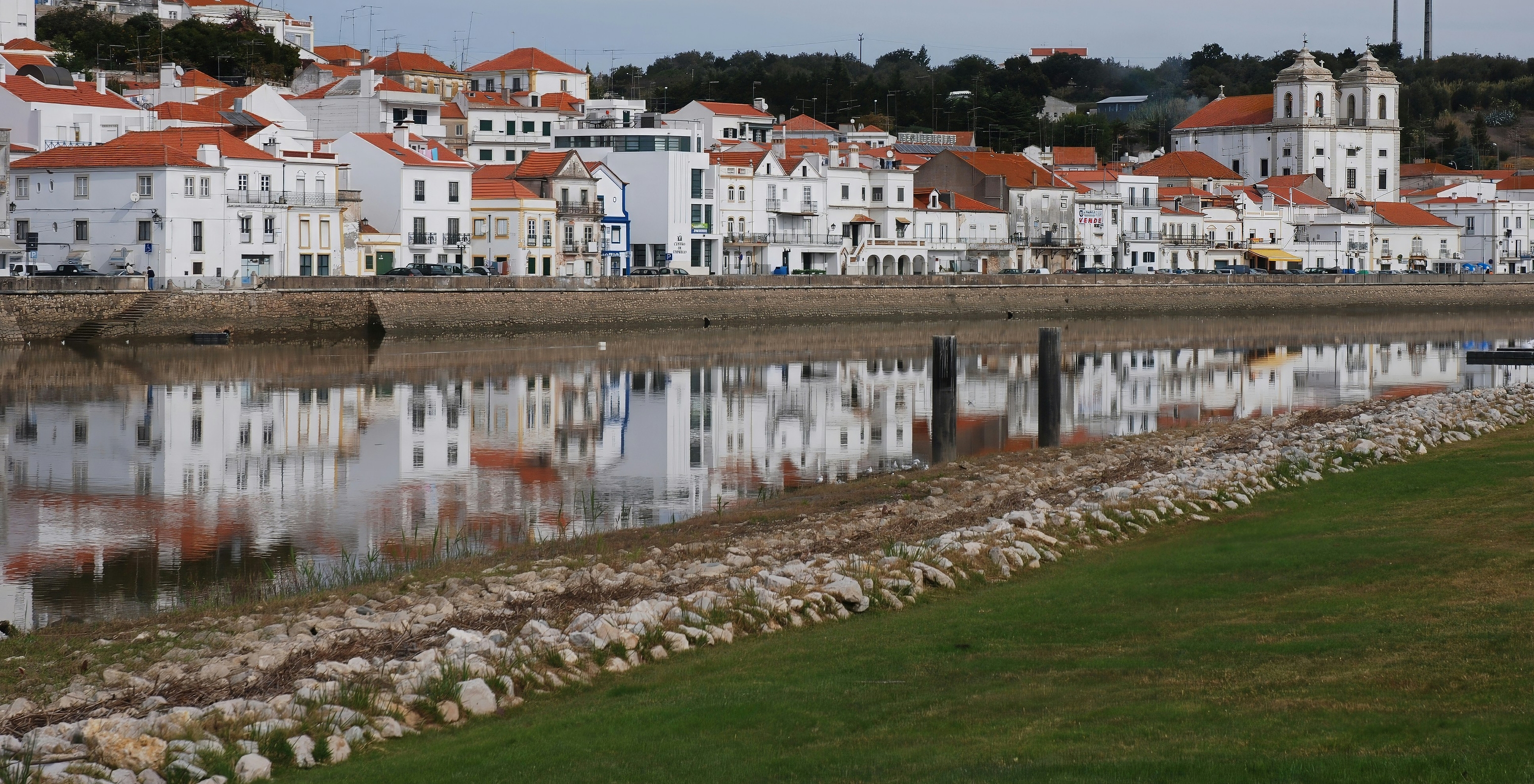 View of the Sado River's shore in Alcácer do Sal, with its typical white houses