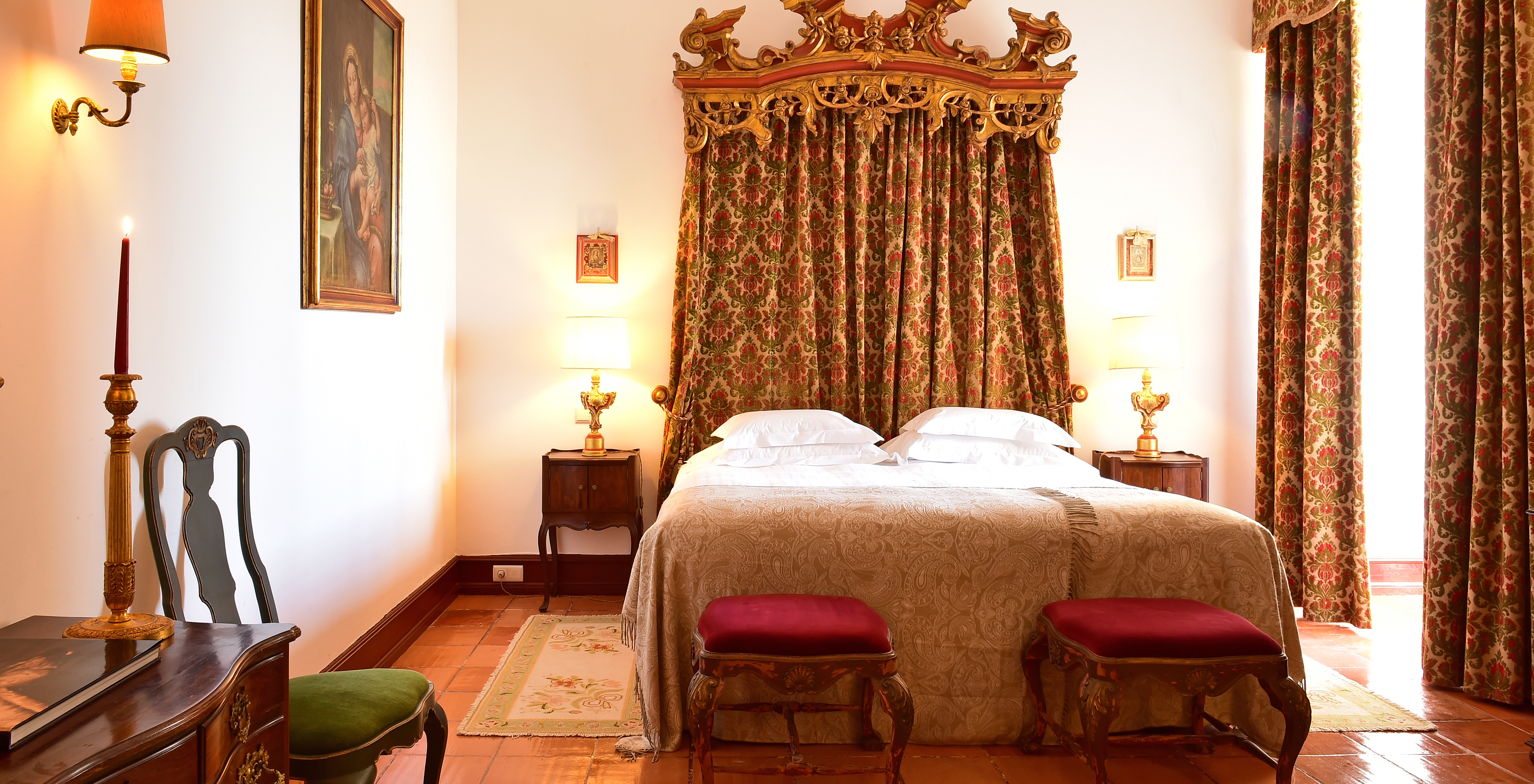 The Special Suite at Pousada Castelo Estremoz has a double bed with a curtain headboard and antique furniture