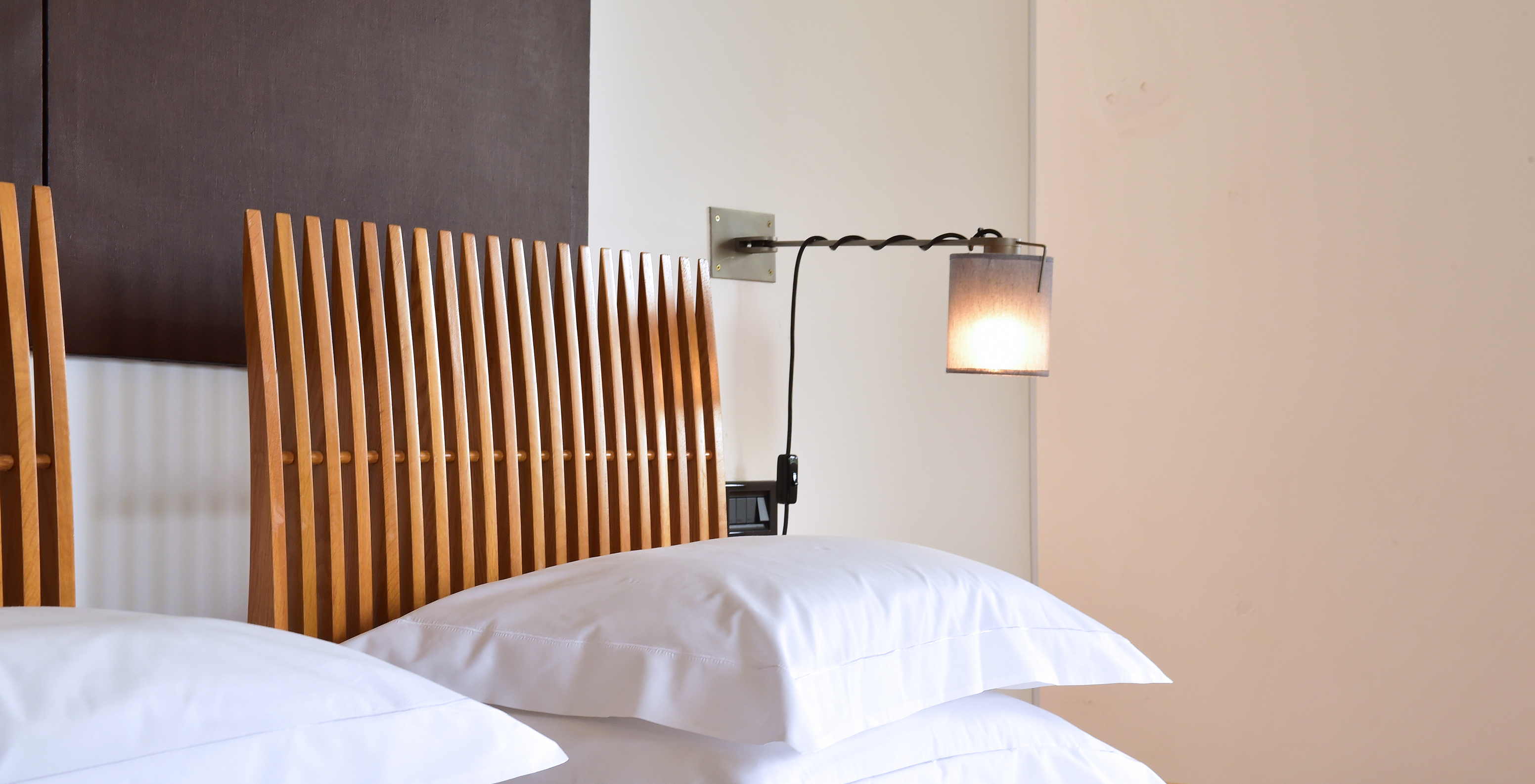 The Classic Room of The Pousada Convento Arraiolos has two single beds with white sheets and a wooden headboard