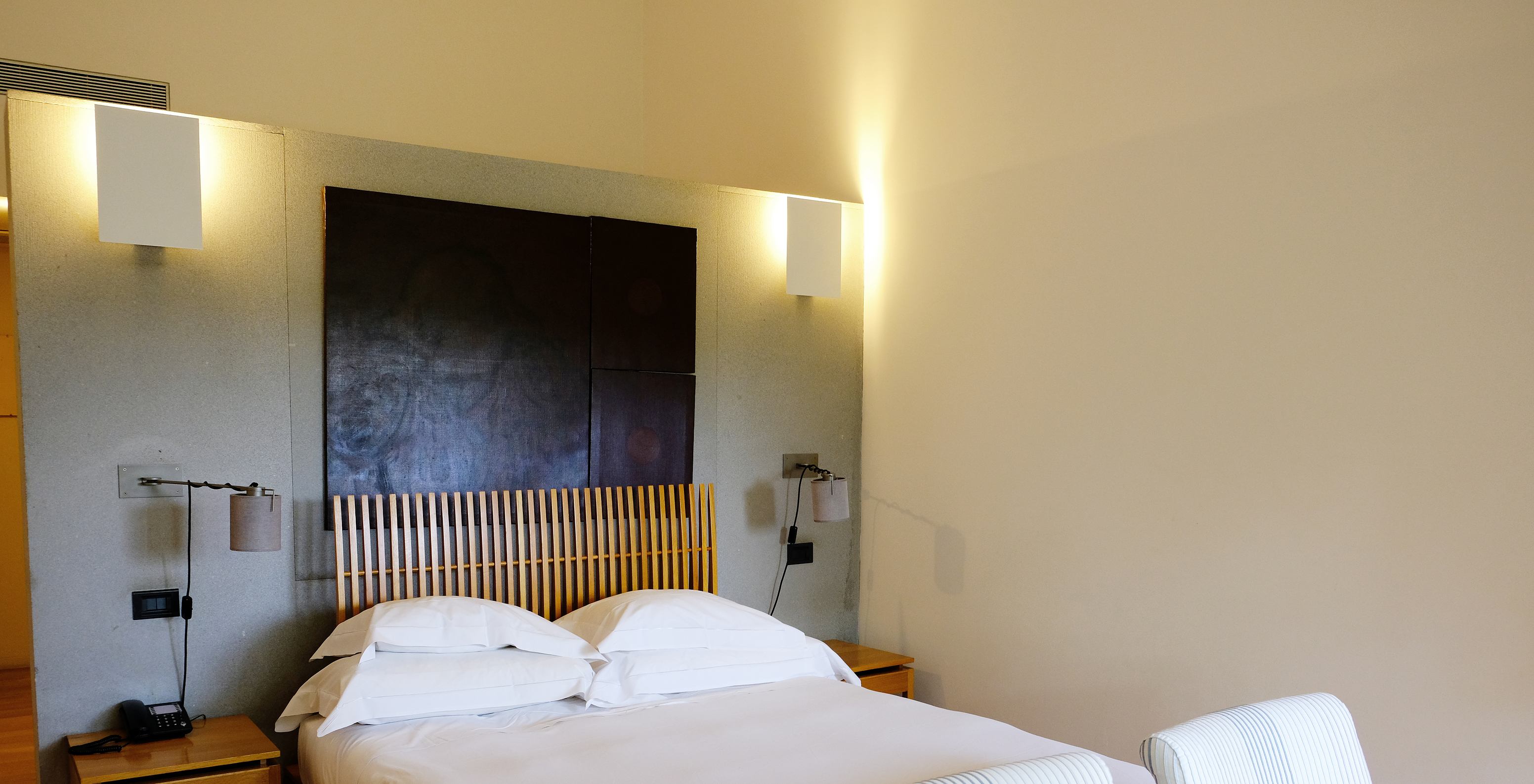 The Family Room of The Pousada Convento Arraiolos has a double bed with bedside tables and two armchairs