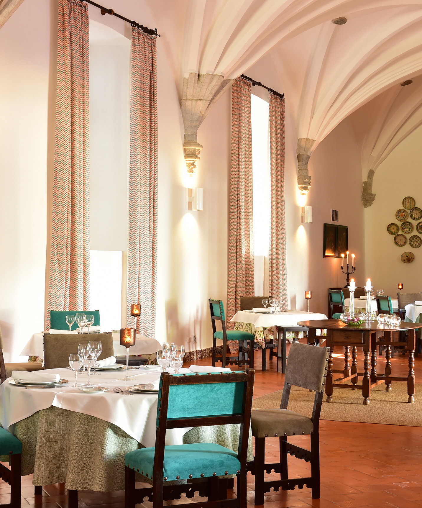 Restaurant at Pousada Convento Beja, with various tables set for guests with blue and beige chairs