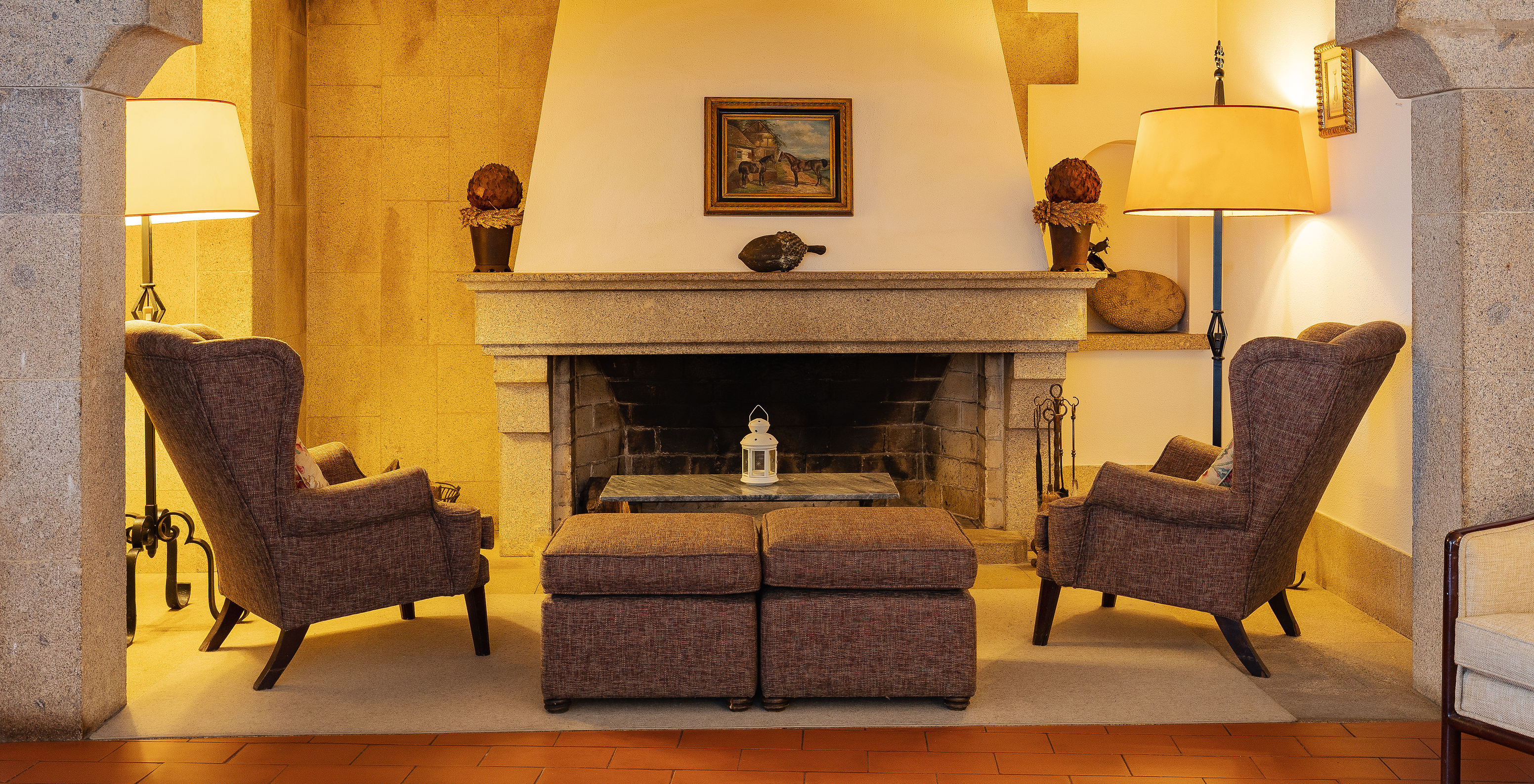 The Pousada Marvão, a hotel in the center of Marvão, has a fireplace with lamps and sofas and armchairs