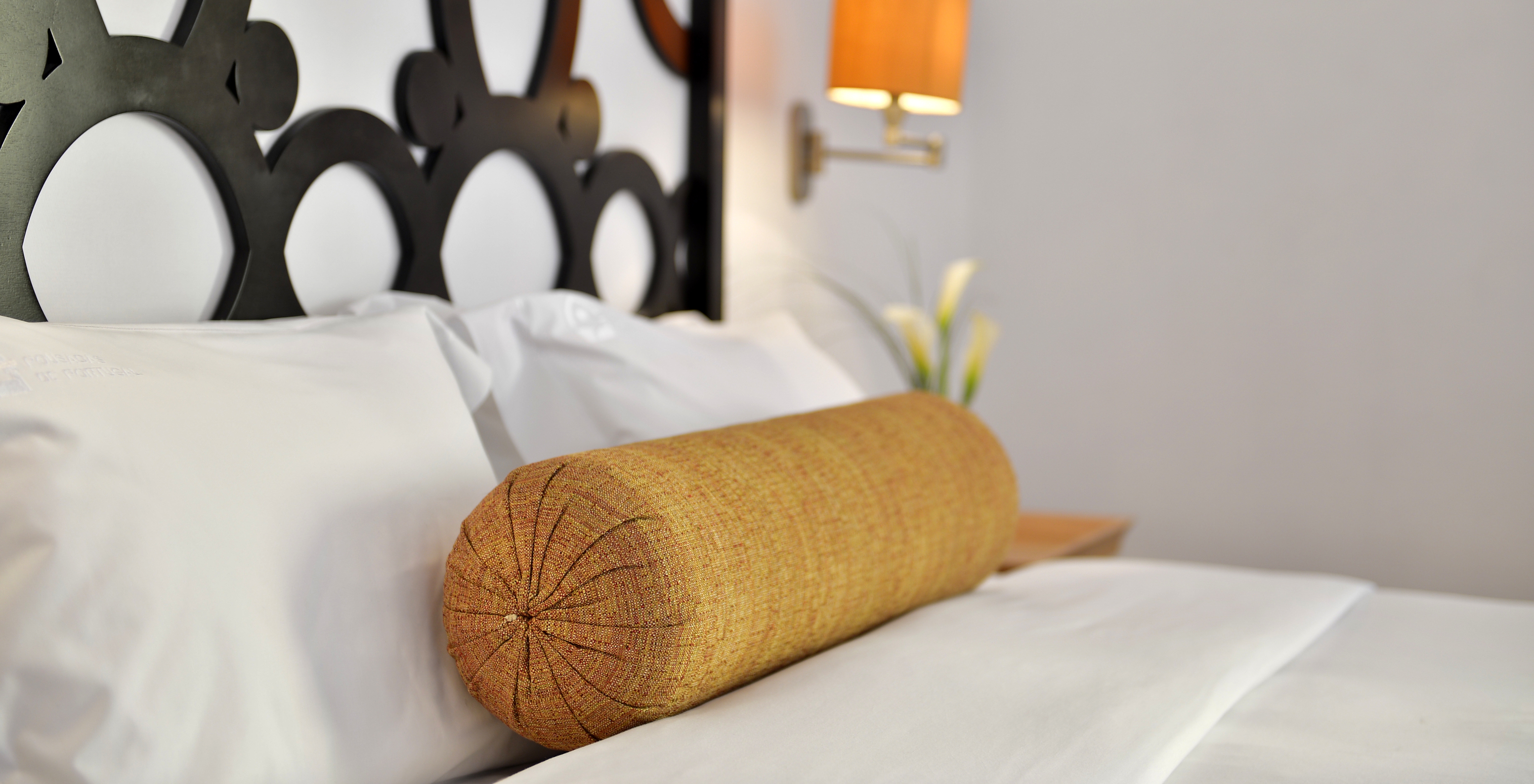 The Double Room of The Pousada Marvão features a bed with a yellow roll-shaped cushion