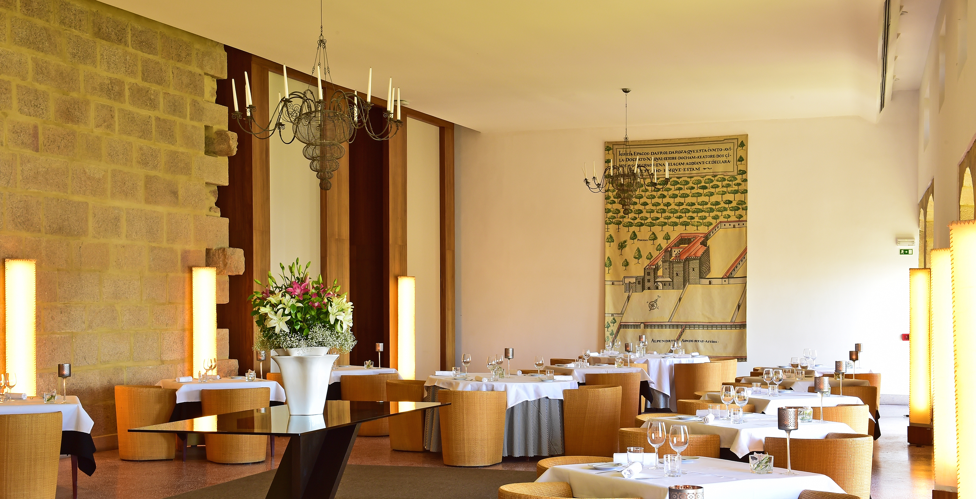 Restaurant at Pousada Mosteiro do Crato with classic and historic decor. Tables with white cloths and wicker chairs