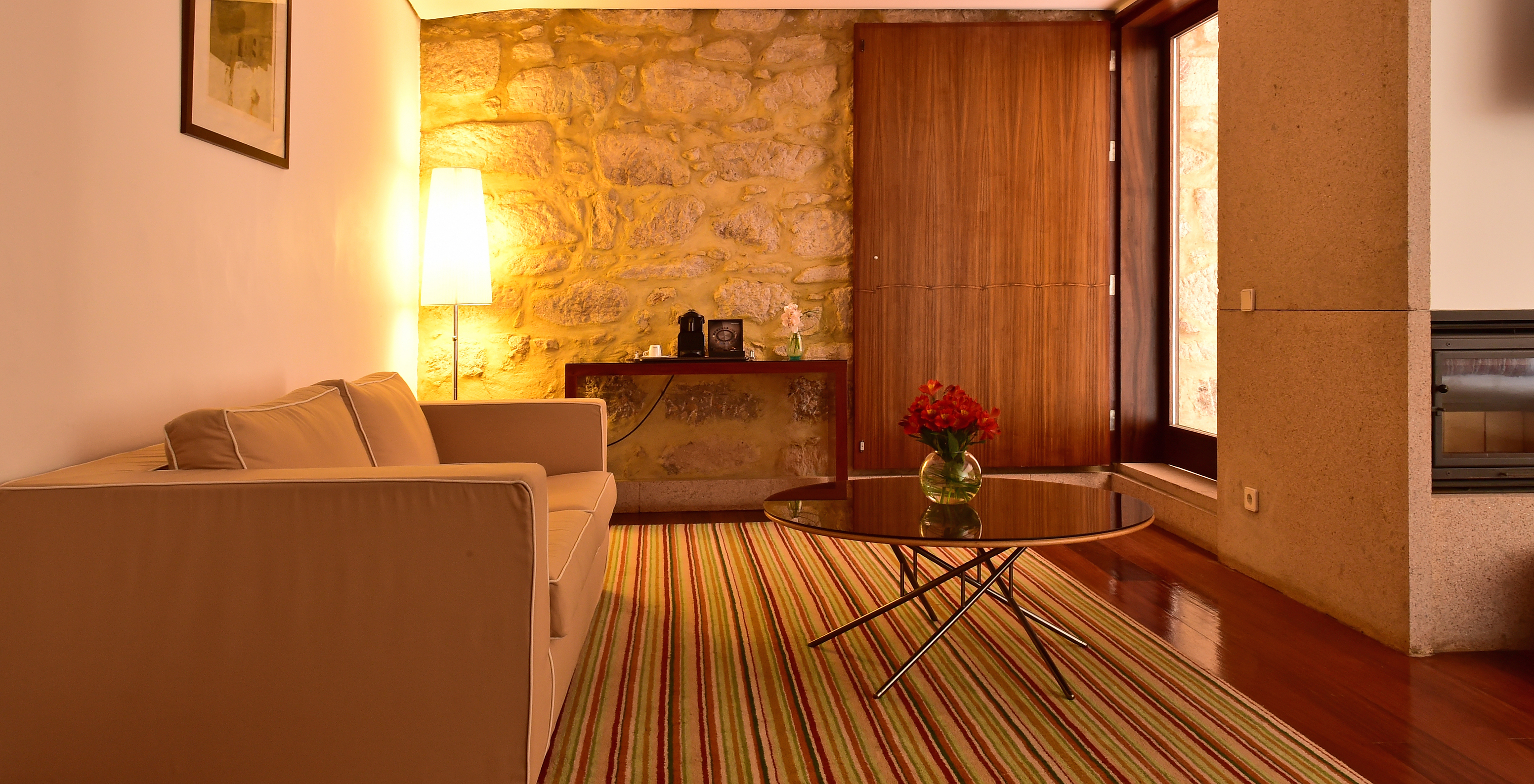 The Standard Suite of The Pousada Mosteiro Crato has a sofa with a small table in the center and a view of the balcony