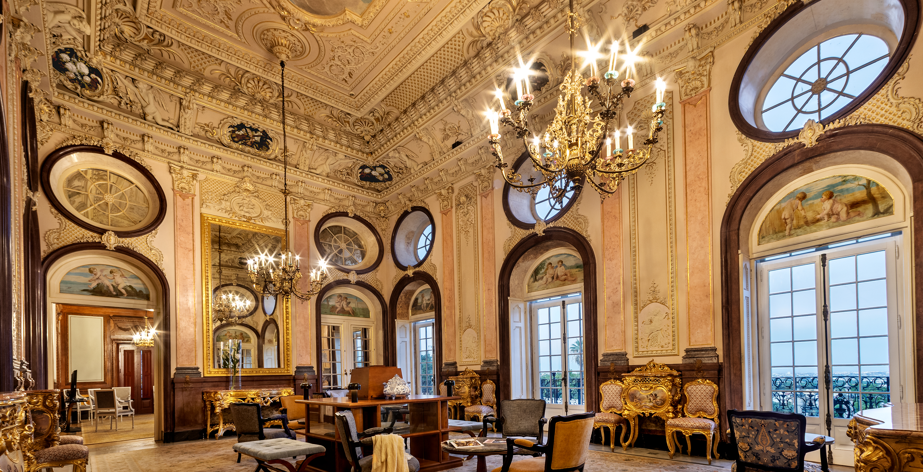 Main hall of the Pousada Palácio Estoi with luxurious decor and crystal chandeliers