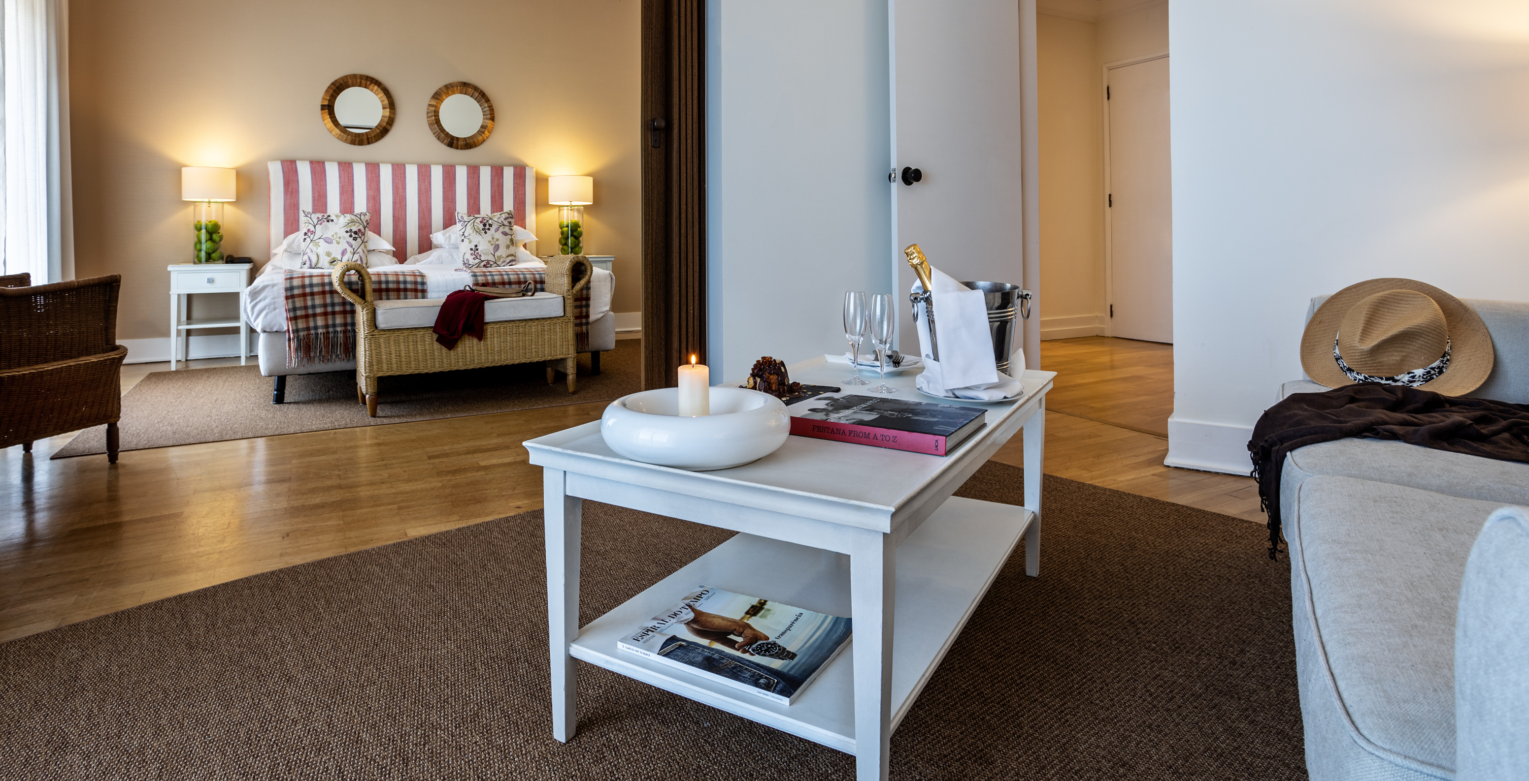 The Master Suite of Pousada Sagres has a living room with a table with champagne, a candle, and a book