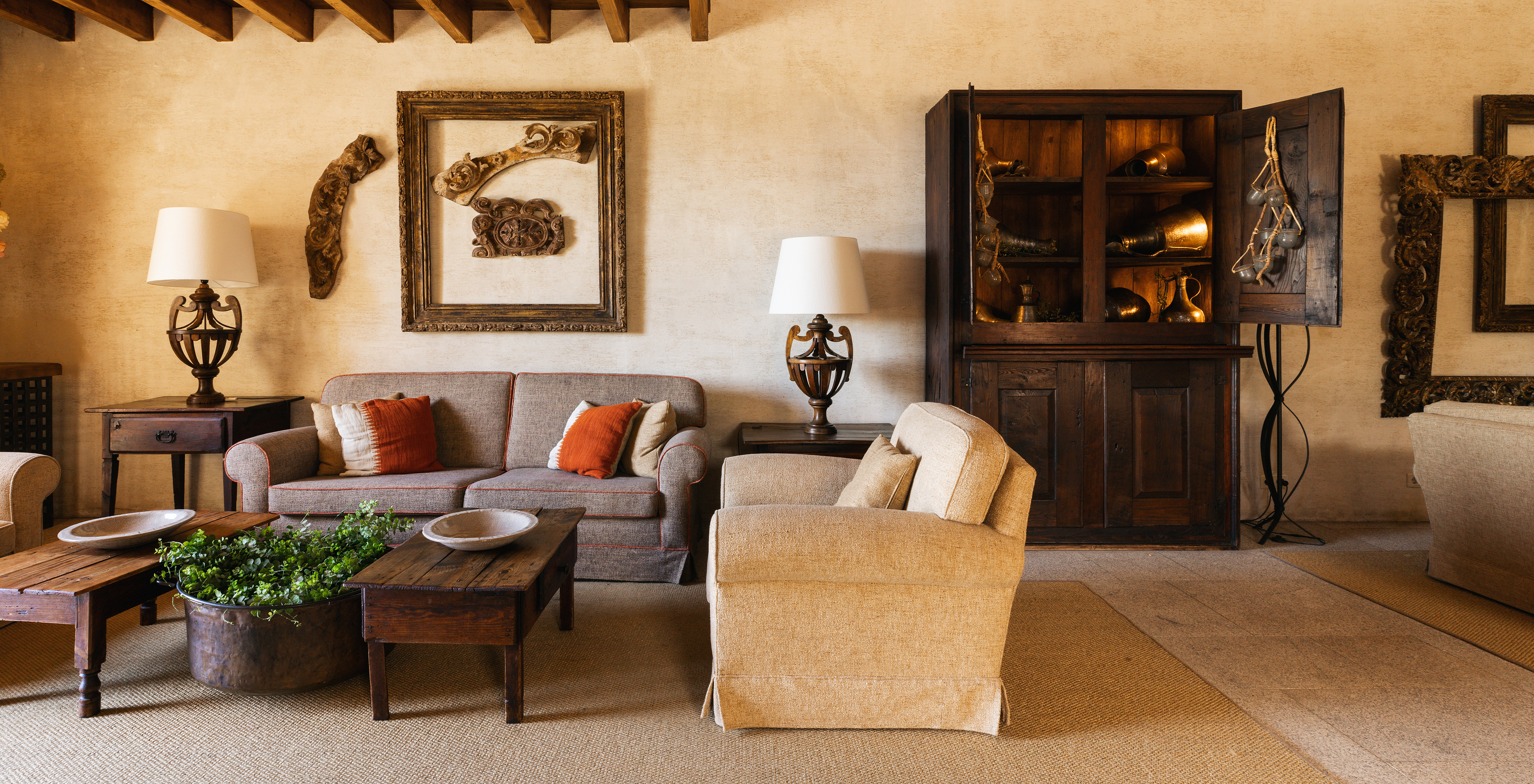 Living room in historic hotel in Belmonte with two sofas and several cabinets matching a rustic decor