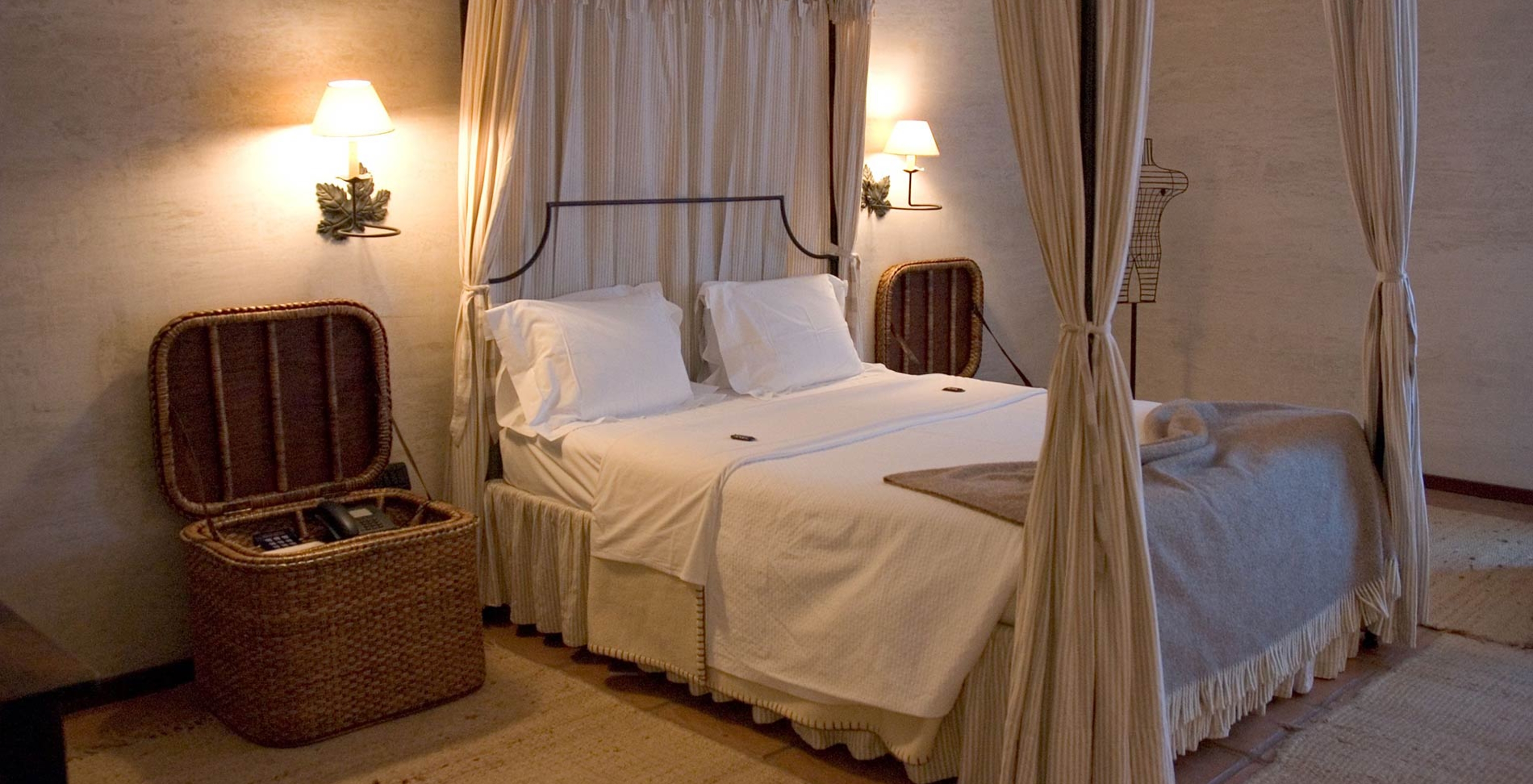 The Classic Room of The Pousada Convento de Belmonte has a double bed and two wicker bedside tables