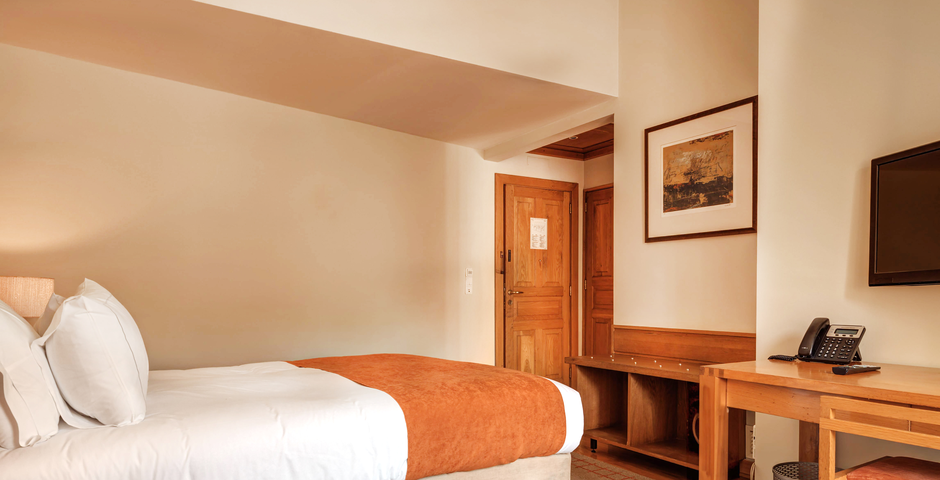 The Family Room of The Pousada Ourém has a double bed with a brick-colored bedspread and carpet