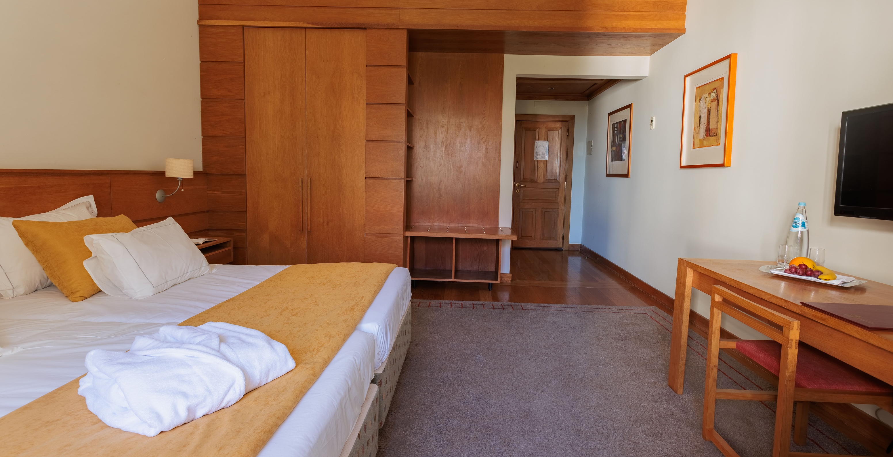 The Suite of The Pousada Ourém features a double bed with a wardrobe beside it and a television in front of the bed