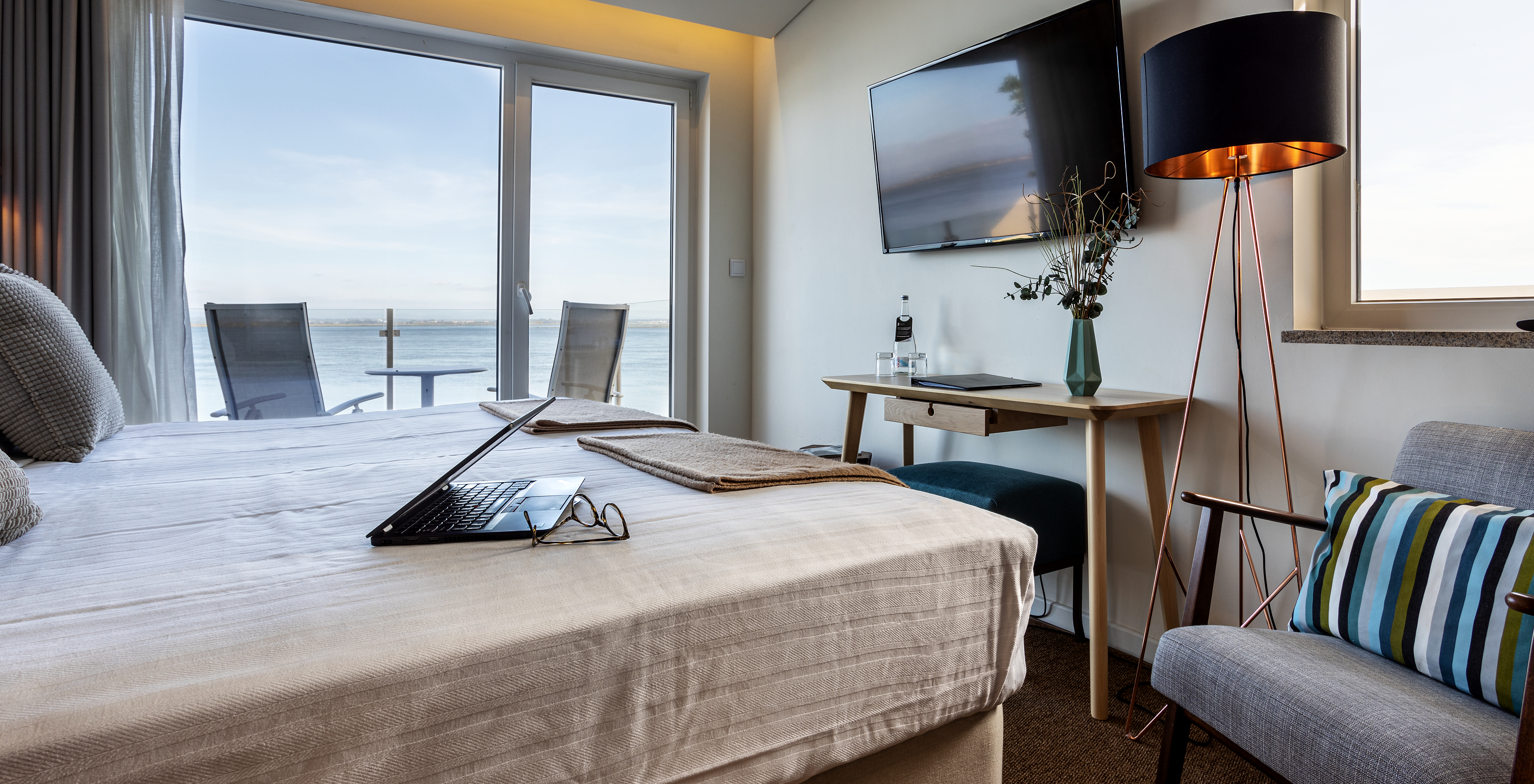 The Premium Room of The Ria Inn - Aveiro has a double bed, a TV, and a balcony with a view of the ria