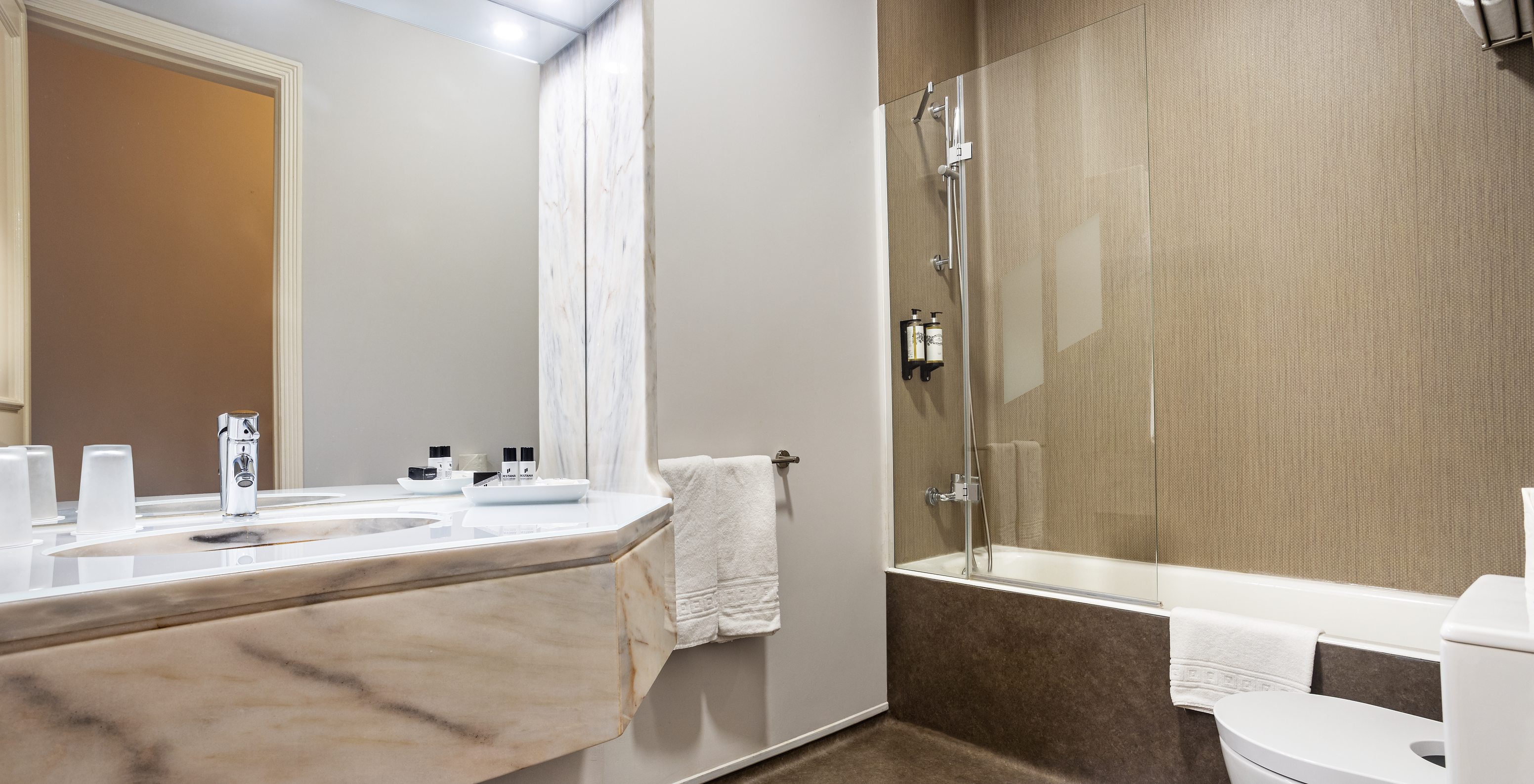 The Classic Room of The Ria Inn - Aveiro has a bathtub with shower, a sink, and a large mirror