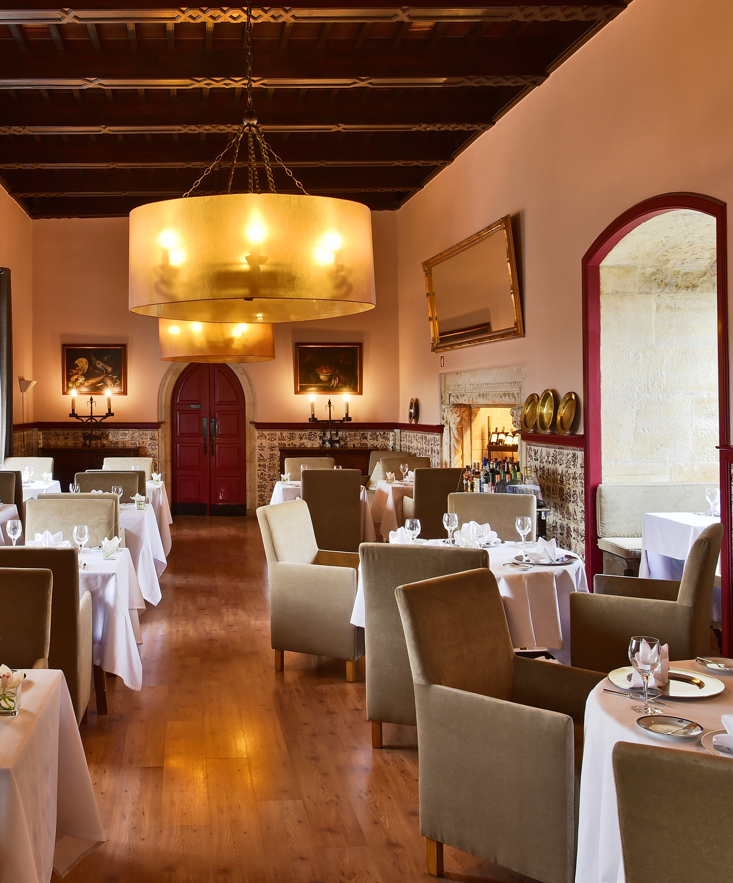 Restaurant at Pousada Vila Óbidos, Bed and Breakfast in Óbidos, with several tables, two lamps, and tiles on the walls