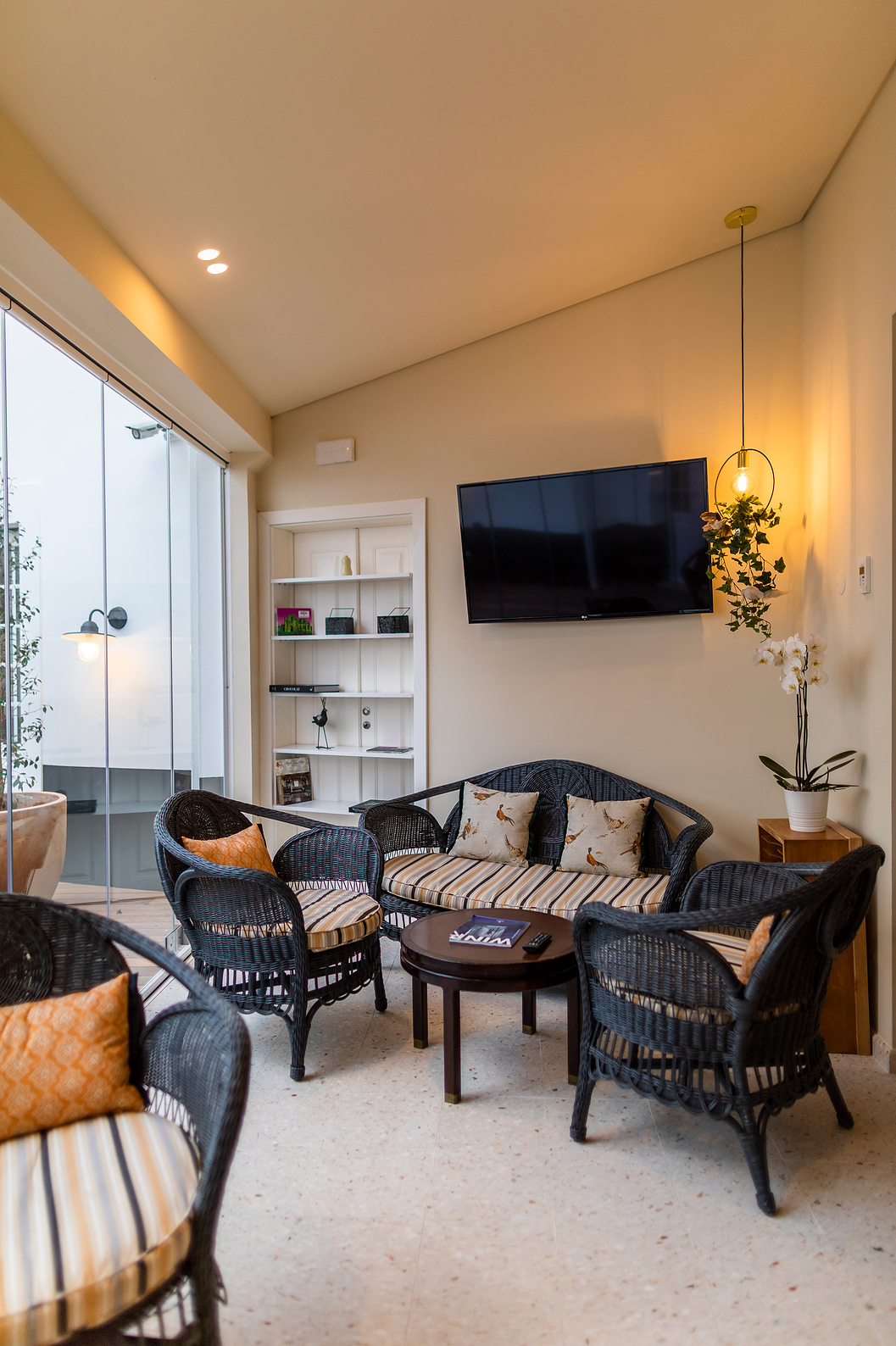 Lounge at Pousada Vila Óbidos, Bed and Breakfast in Óbidos, with a TV and black rattan chairs with cushions