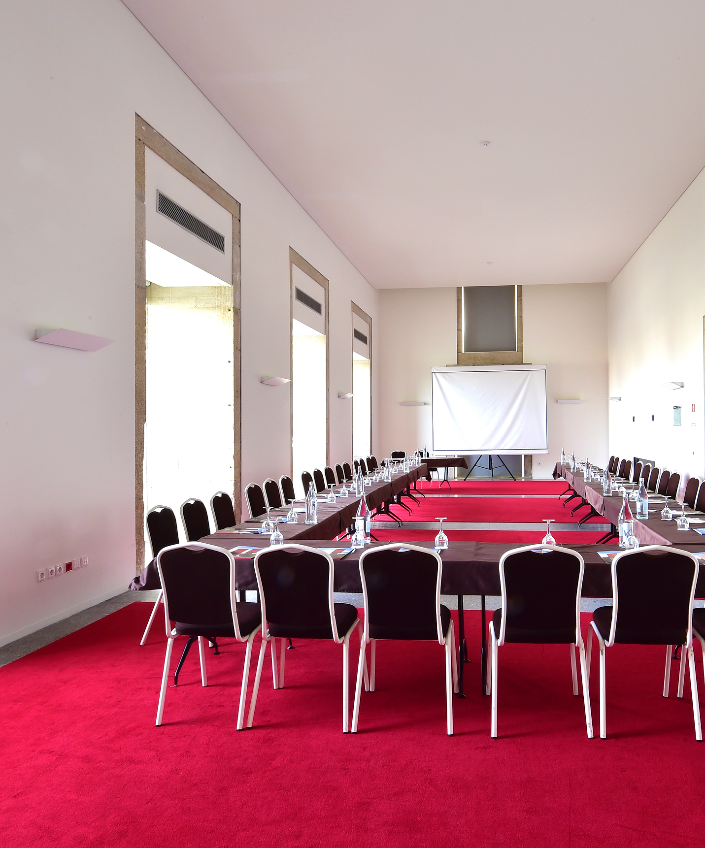 Pousada Viseu, hotel with pool in Viseu, has a meeting room with several tables and chairs and a white screen in the back