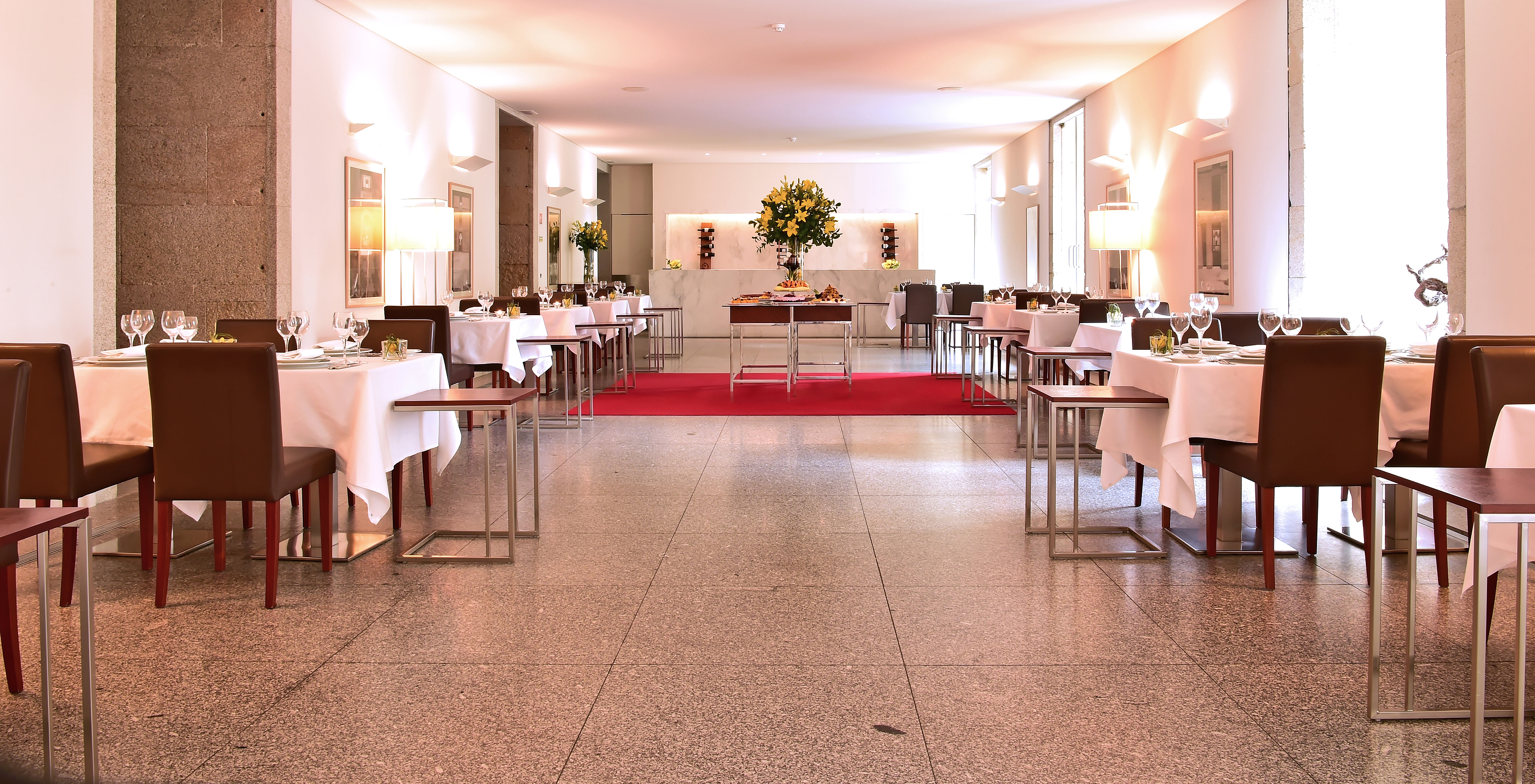 Restaurant at Pousada Viseu, with tables and chairs and some artworks on the white walls