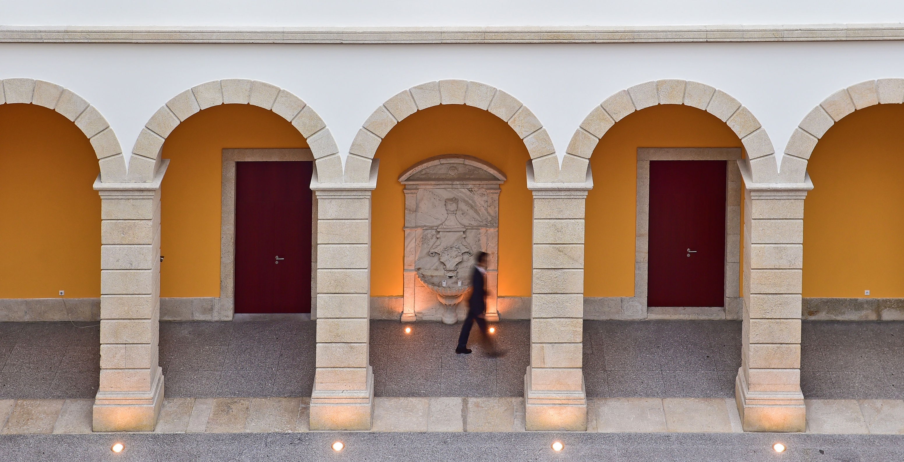 Historic arcades at Pousada Viseu, made of stone, with white walls and stone flooring