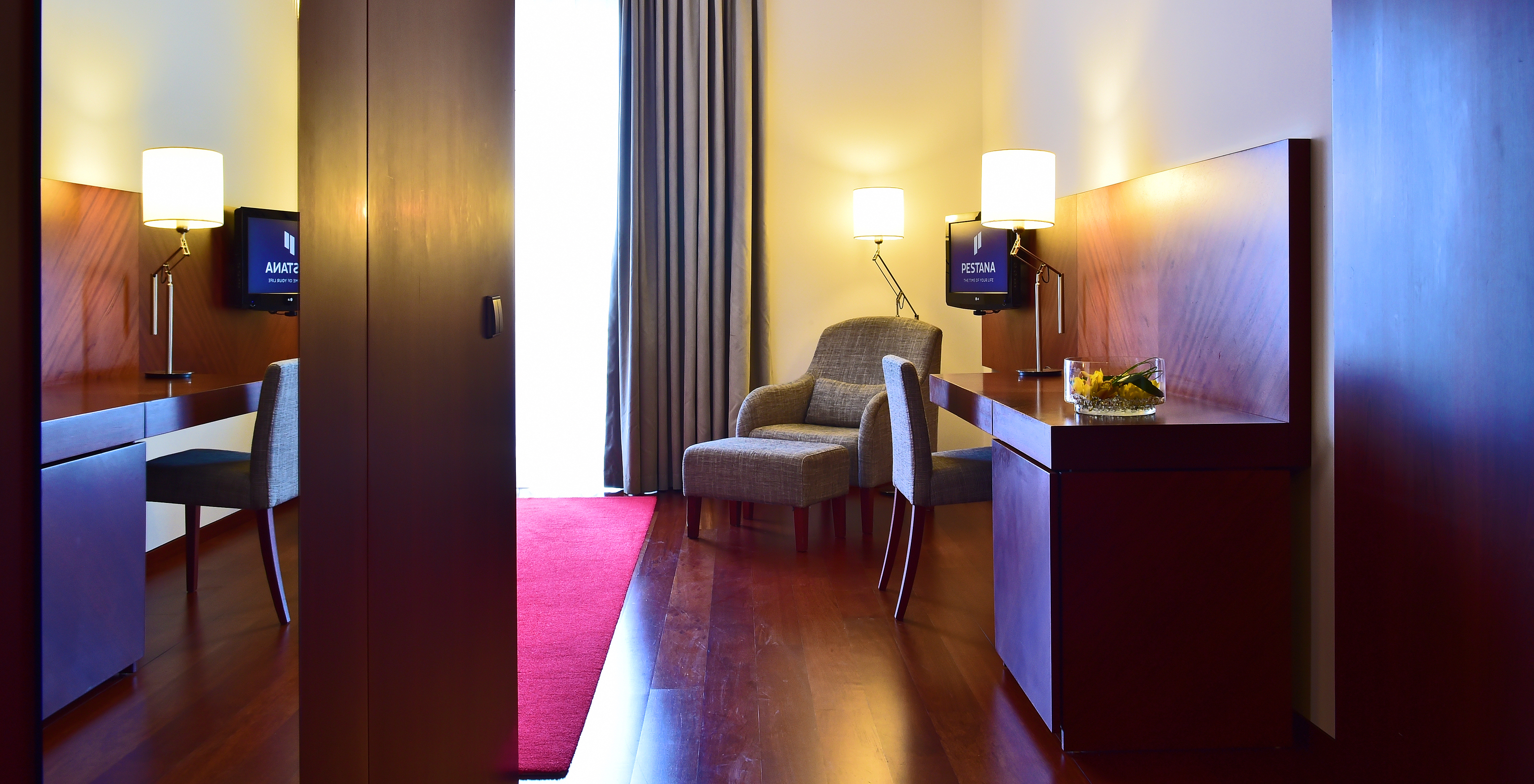 The Classic Room of the Pousada Viseu has a mirror, a wardrobe, desk, television and an armchair