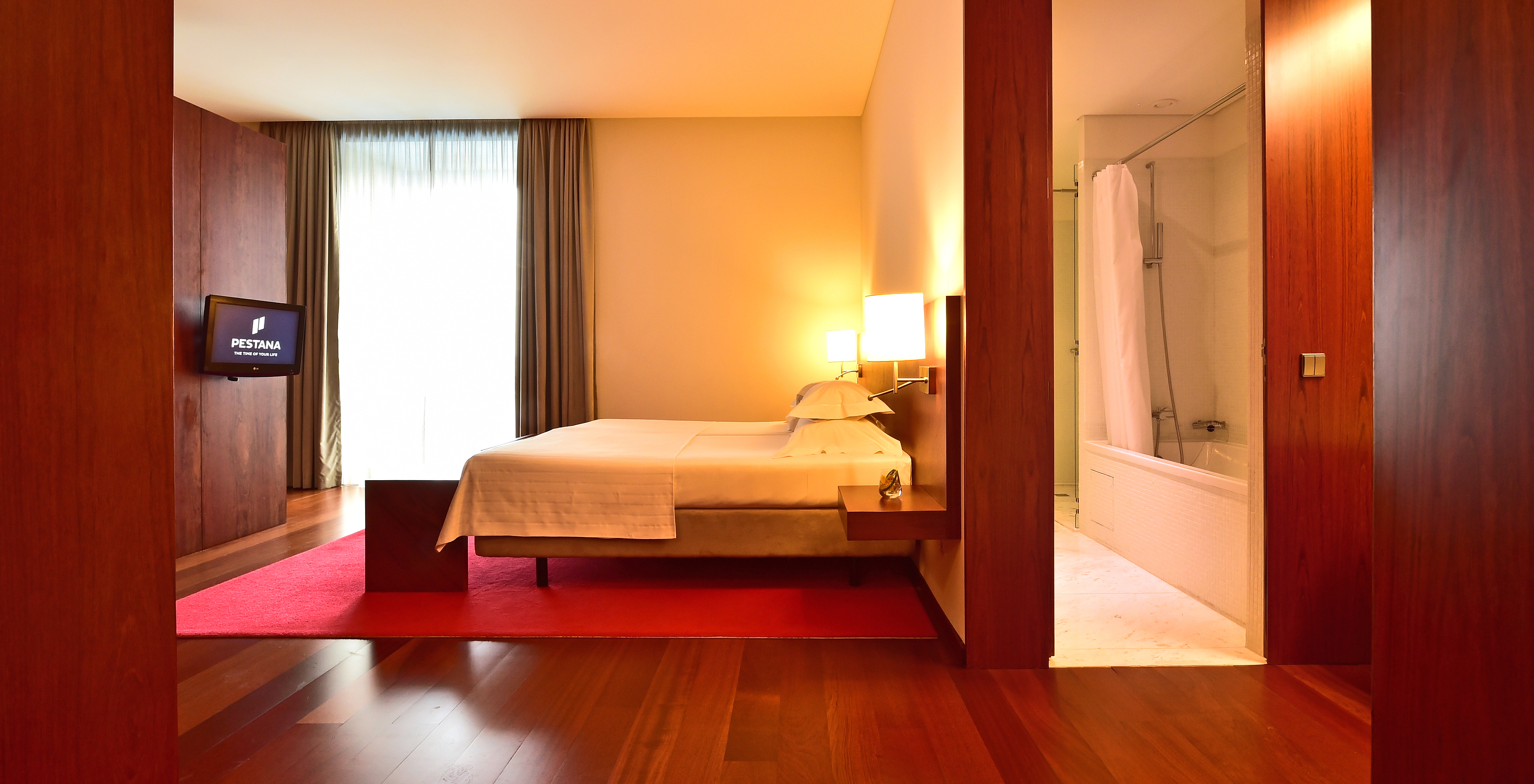 The Standard Suite of the Pousada Viseu has a double bed, television, and a bathroom with bathtub