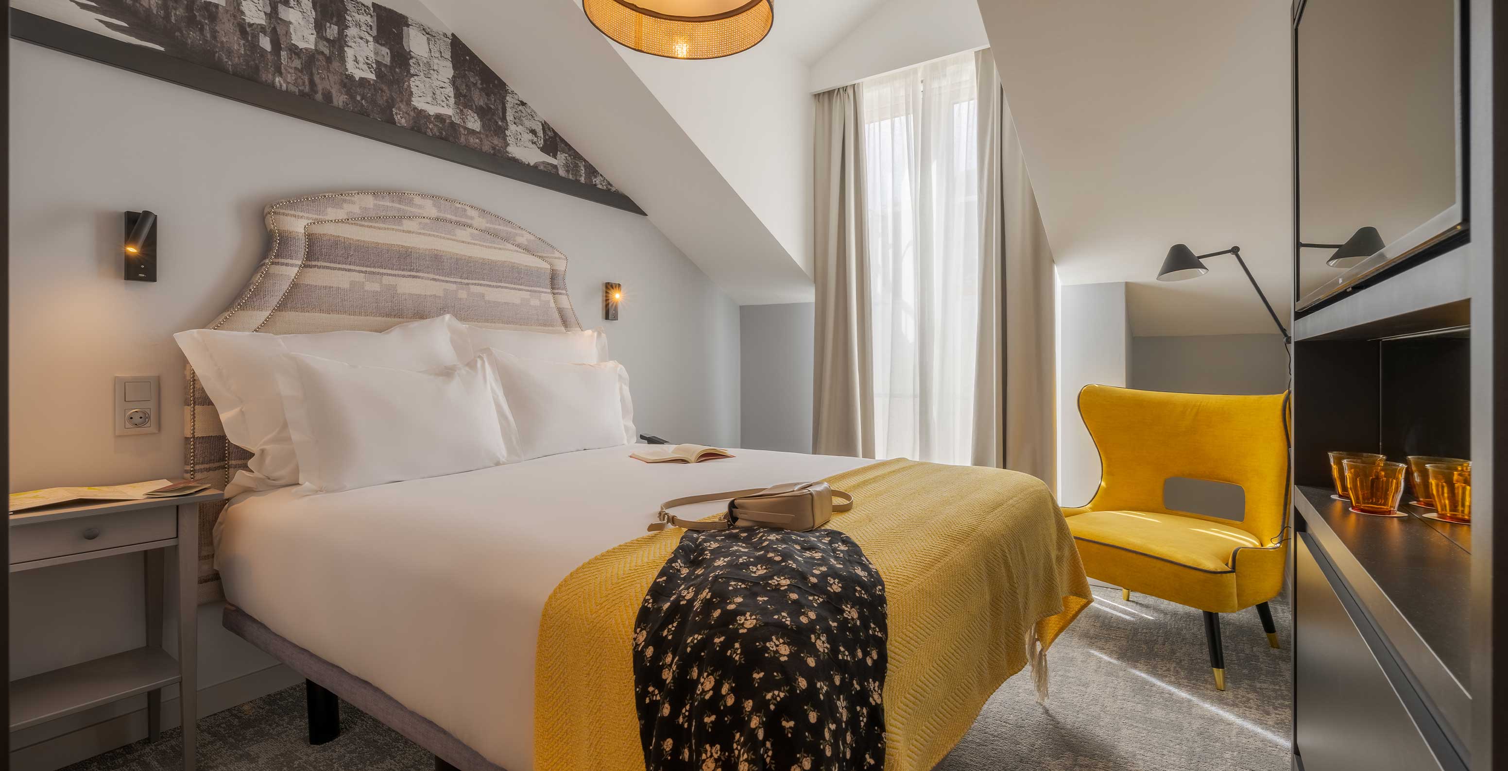 The Attic at Pousada Alfama has a double bed and the room is decorated in yellow tones and has a sloping ceiling