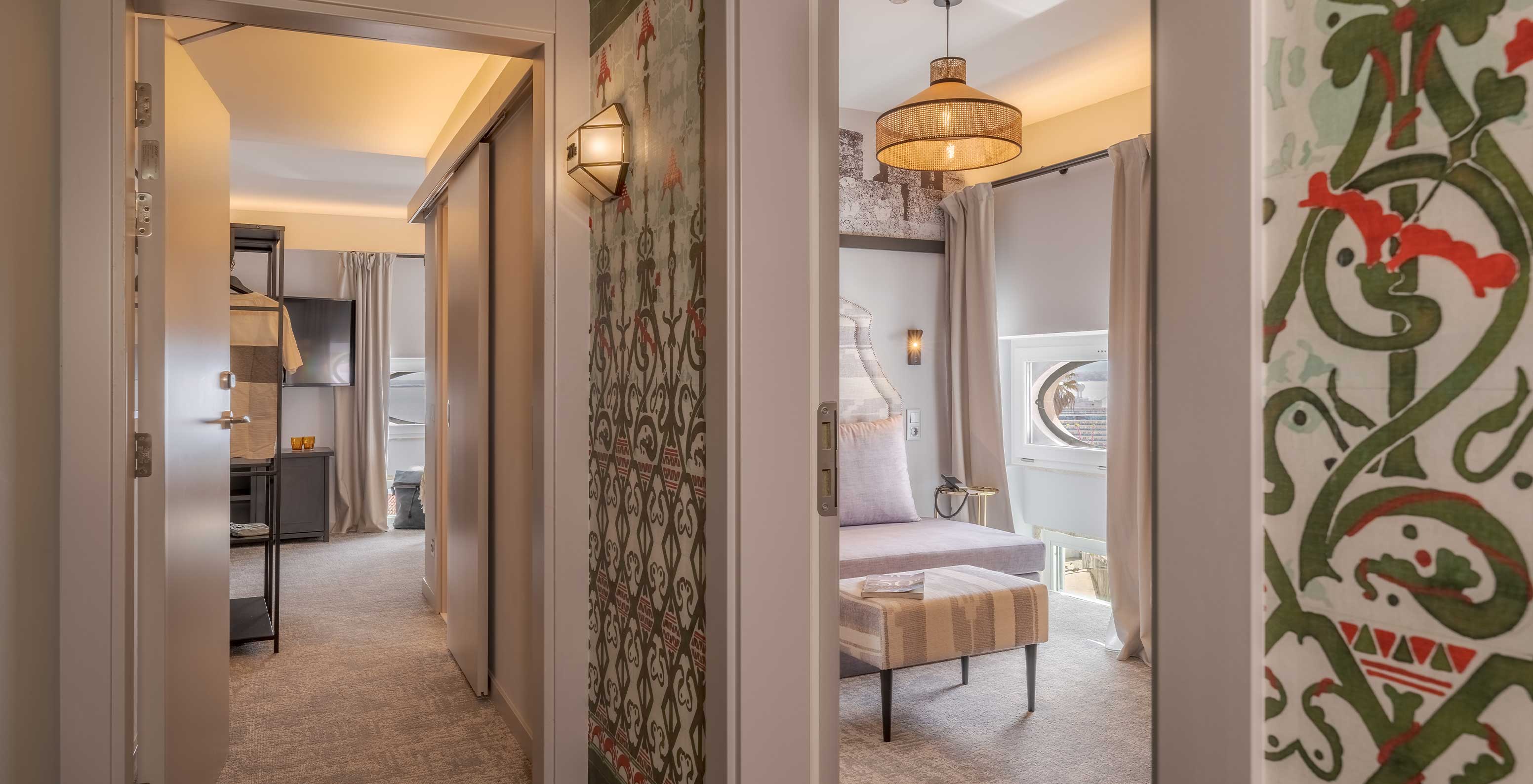 The Portas do Sol Suite at Pousada Alfama has a corridor connecting the living room and the room with the double bed