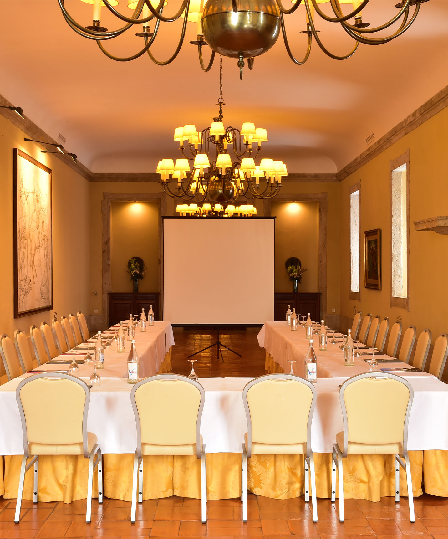 The Pousada Castelo Palmela, a hotel in Palmela, has a meeting room with a U-shaped table, water, and chairs