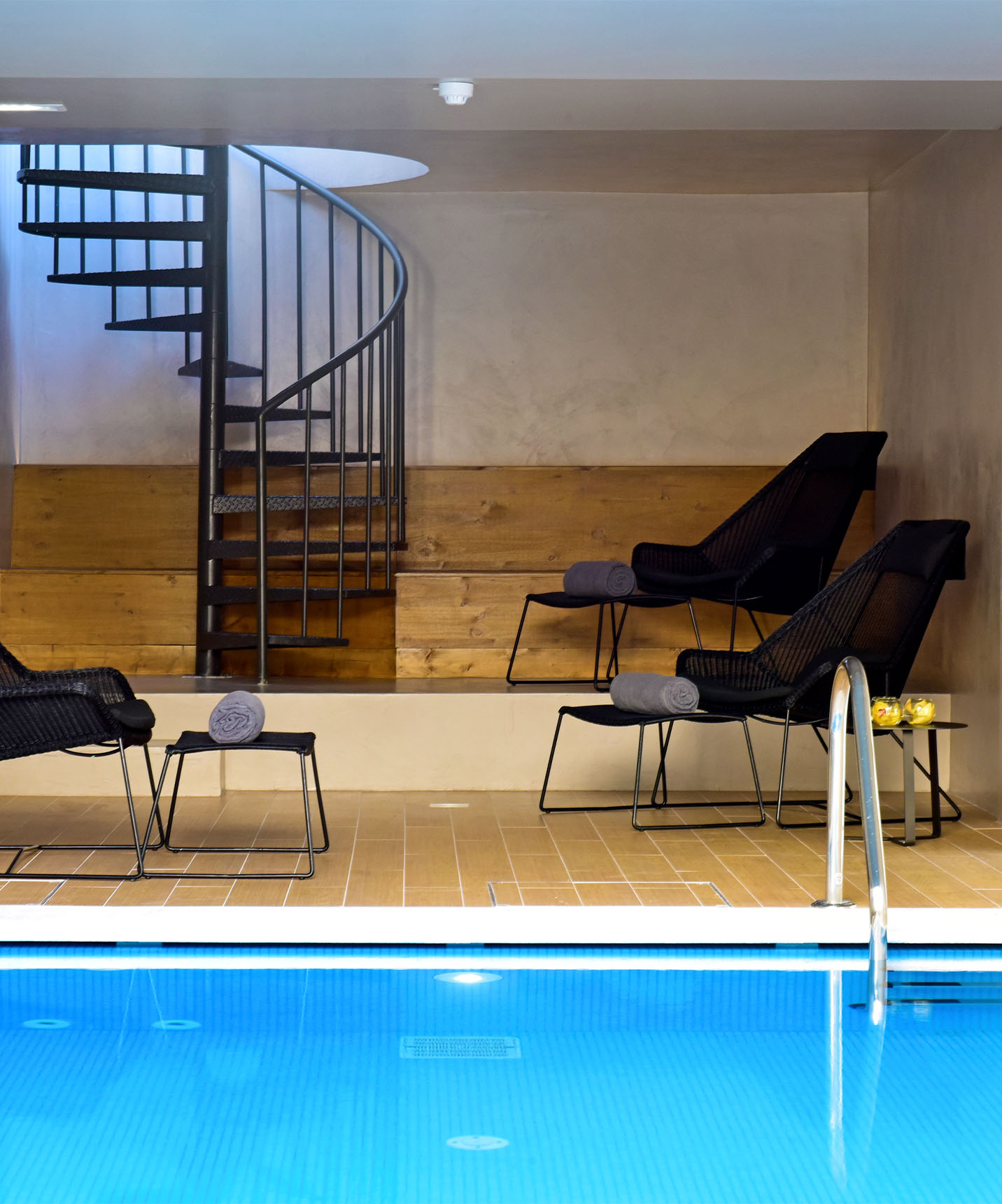 Indoor pool at Pousada Lisboa Praça do Comércio, a historic hotel in Lisbon, with chairs and towels for relaxing