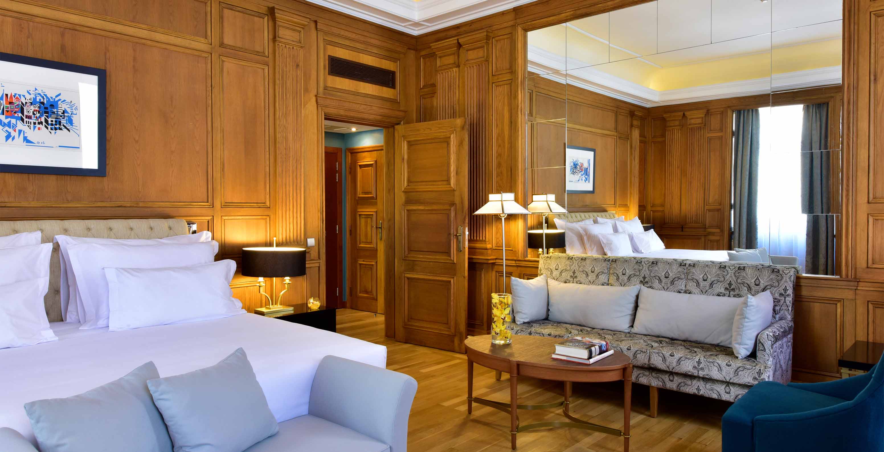 The Áurea Suite King Size Bed of The Pousada Lisboa Praça do Comércio has a sofa, an armchair at the foot of the double bed